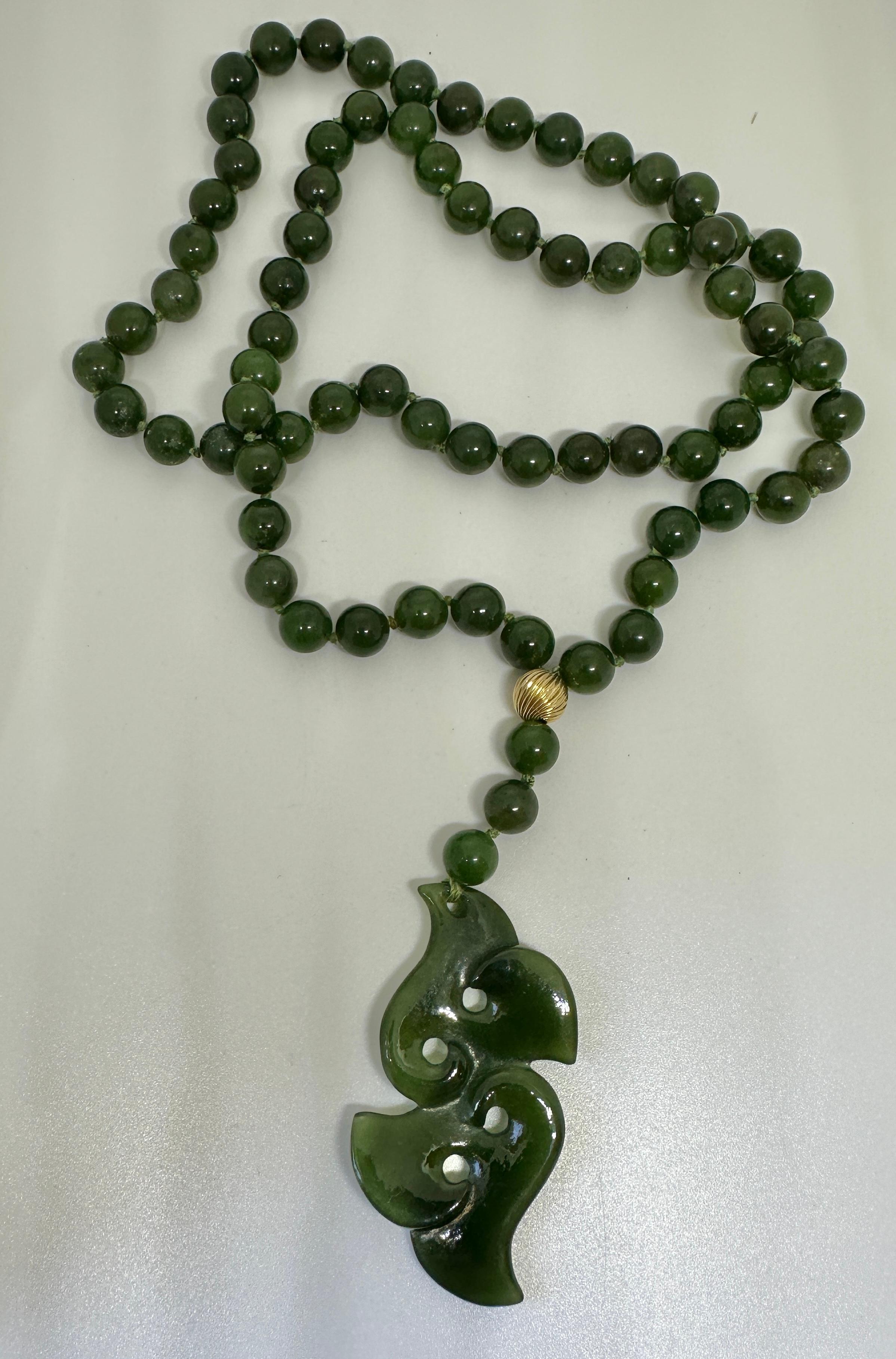 IL S'AGIT D'UN EXQUIS COLLIER ART DÉCO EN JADE ET OR JAUNE 10 CARATS, AVEC PERLES ET PENDENTIFS, D'UNE LONGUEUR DE 26 POUCES.  CE SUPERBE COLLIER COMPORTE UN FABULEUX PENDENTIF EN JADE SCULPTÉ ET UNE CHAÎNE COMPOSÉE DE SUPERBES PERLES DE JADE DE 8