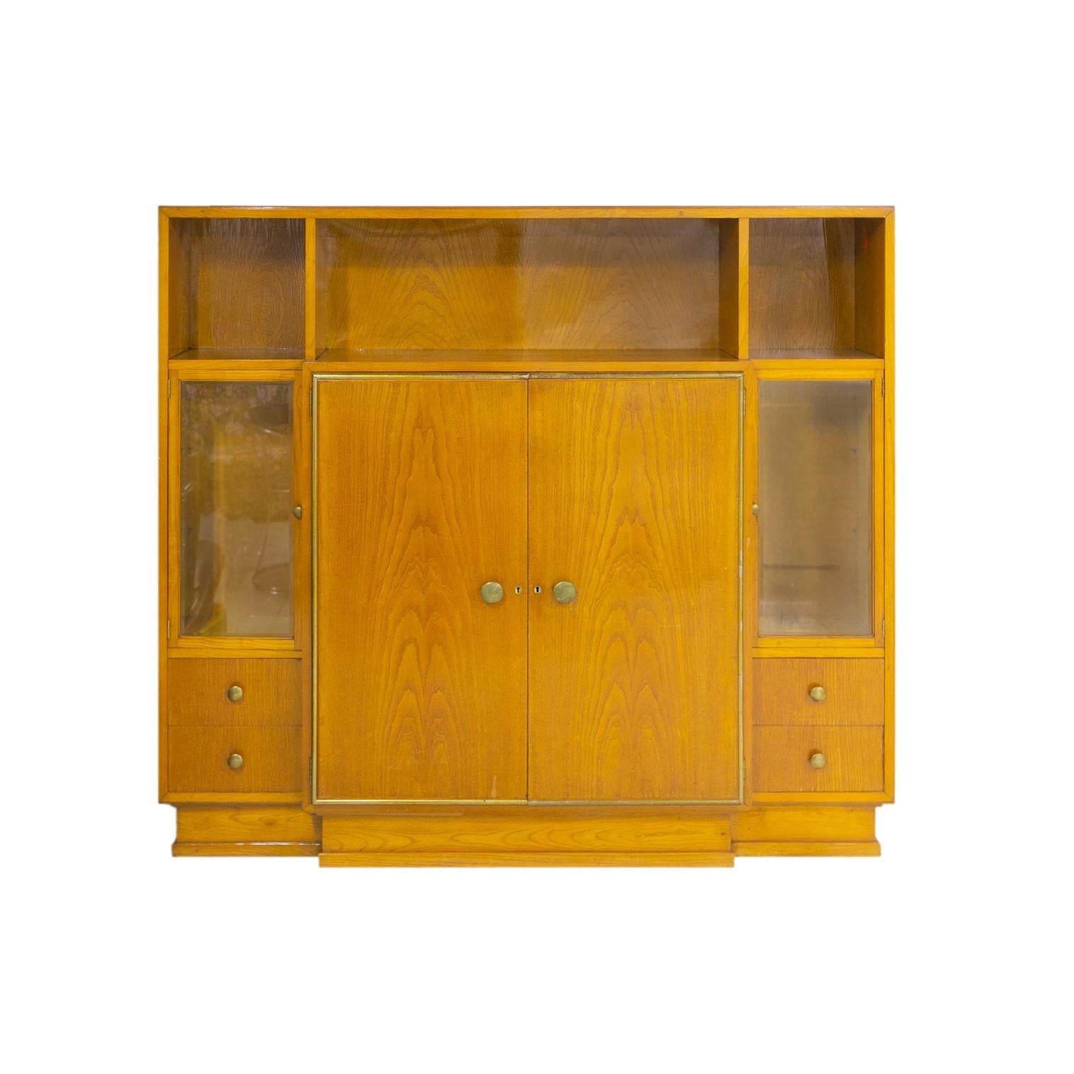 Una única  Vitrina / armario de madera de abeto en color claro, ideal para uso mixto (libros o vajilla) con estantes superiores y compartimentos vitrina laterales y estantes interiores en el centro y herrajes metálicos. 
Orden, color, geometría,