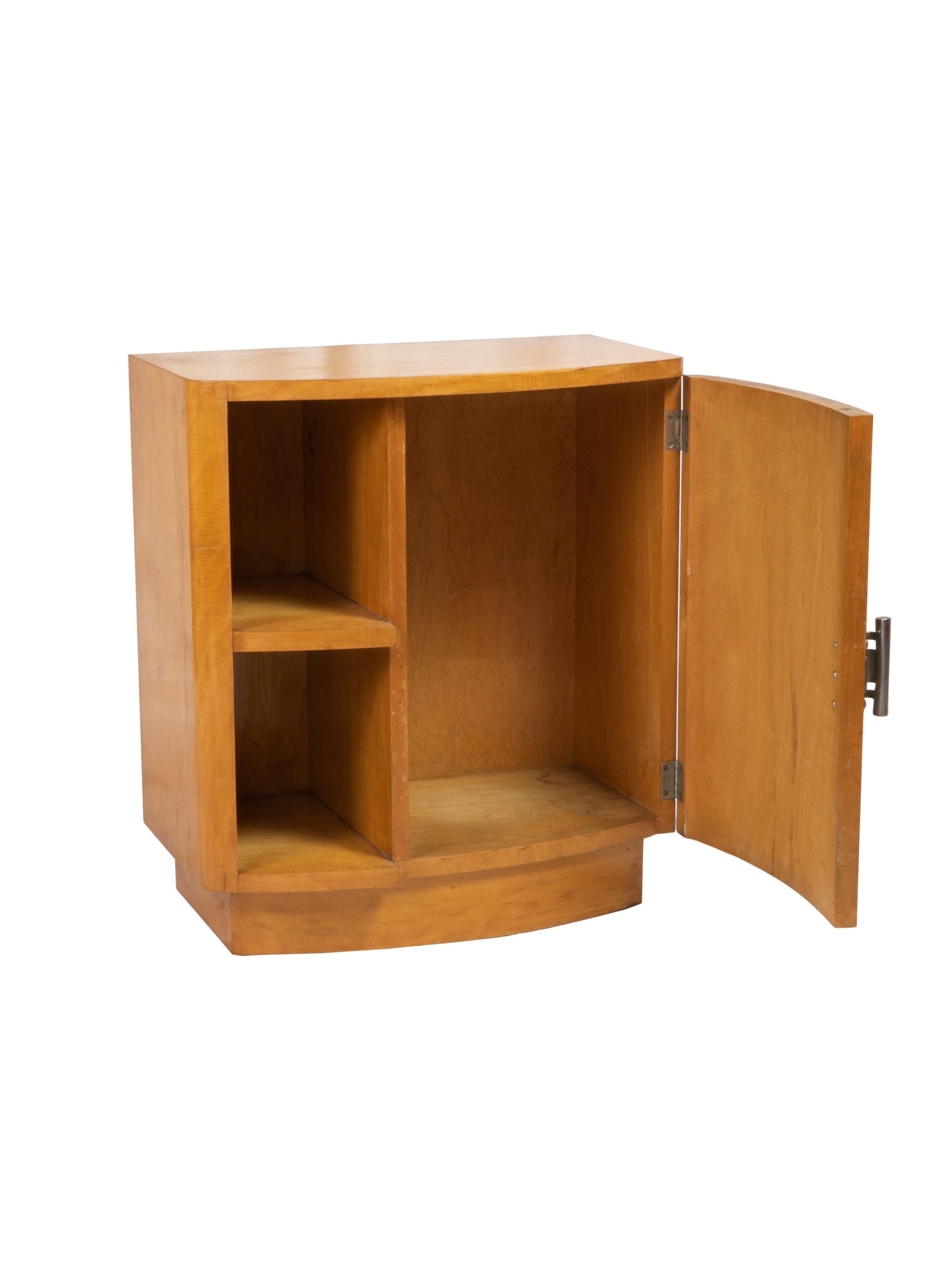 An elegant light color  spruce wood support piece with a bookcase on the left side and door on the right side. Small piece within hardware.
Order, color, geometry, words that define the Art Deco world. 
In Portugal, examples like this one were