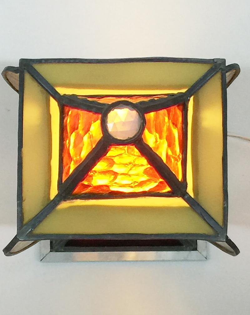 Art Deco square and organic shaped stained glass table lamp 

An Art Deco lamp, made in stained glass  in the colors, 2 x blue, orange, yellow, green and red glass
2 parts of the glass is broken, see details in the photos
The lamp is raised on an