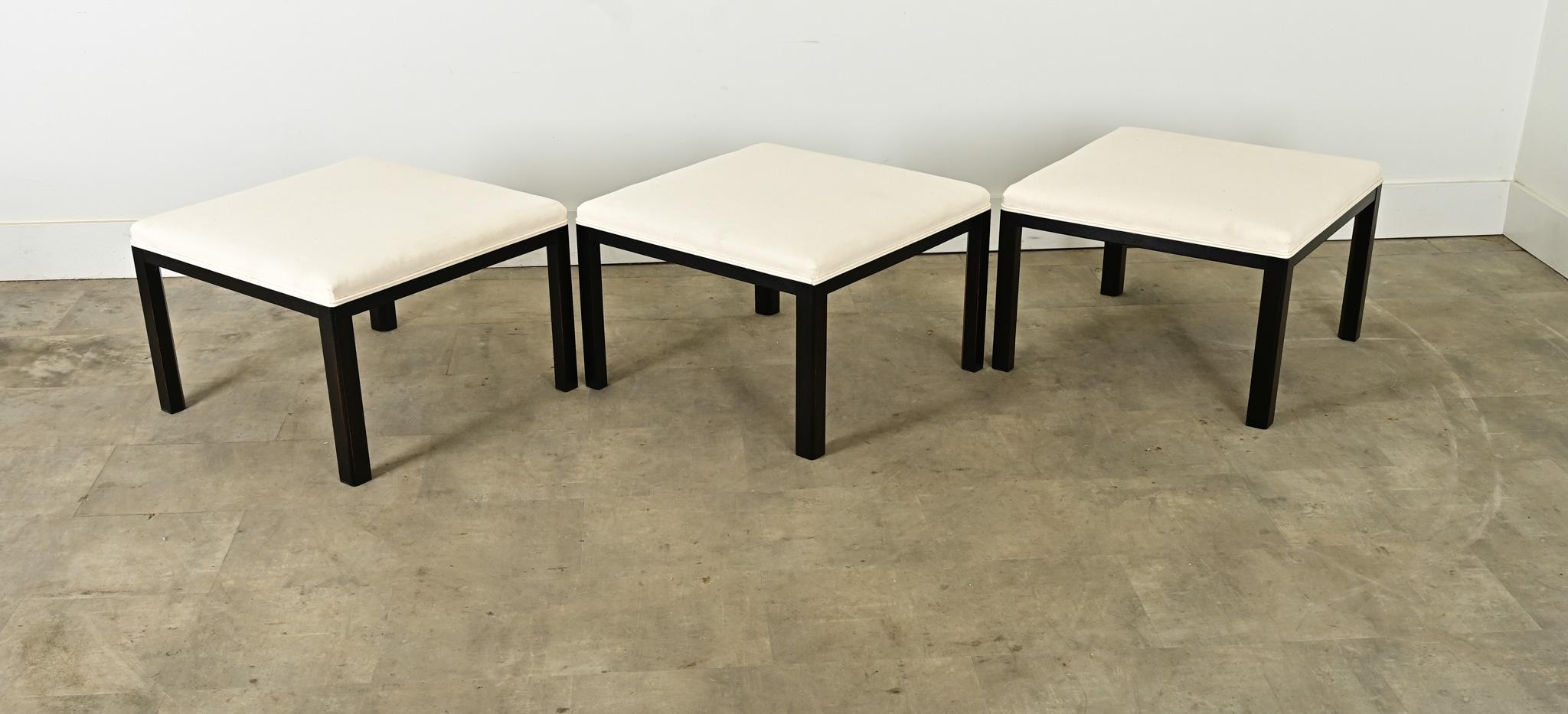 A vintage 20th century square bench, ottoman, or footstool with unlimited potential around the home. Art Deco in style, the white twill seat is a blank canvas to use for extra seating or place a tray-becoming an instant cocktail table. Ebonized