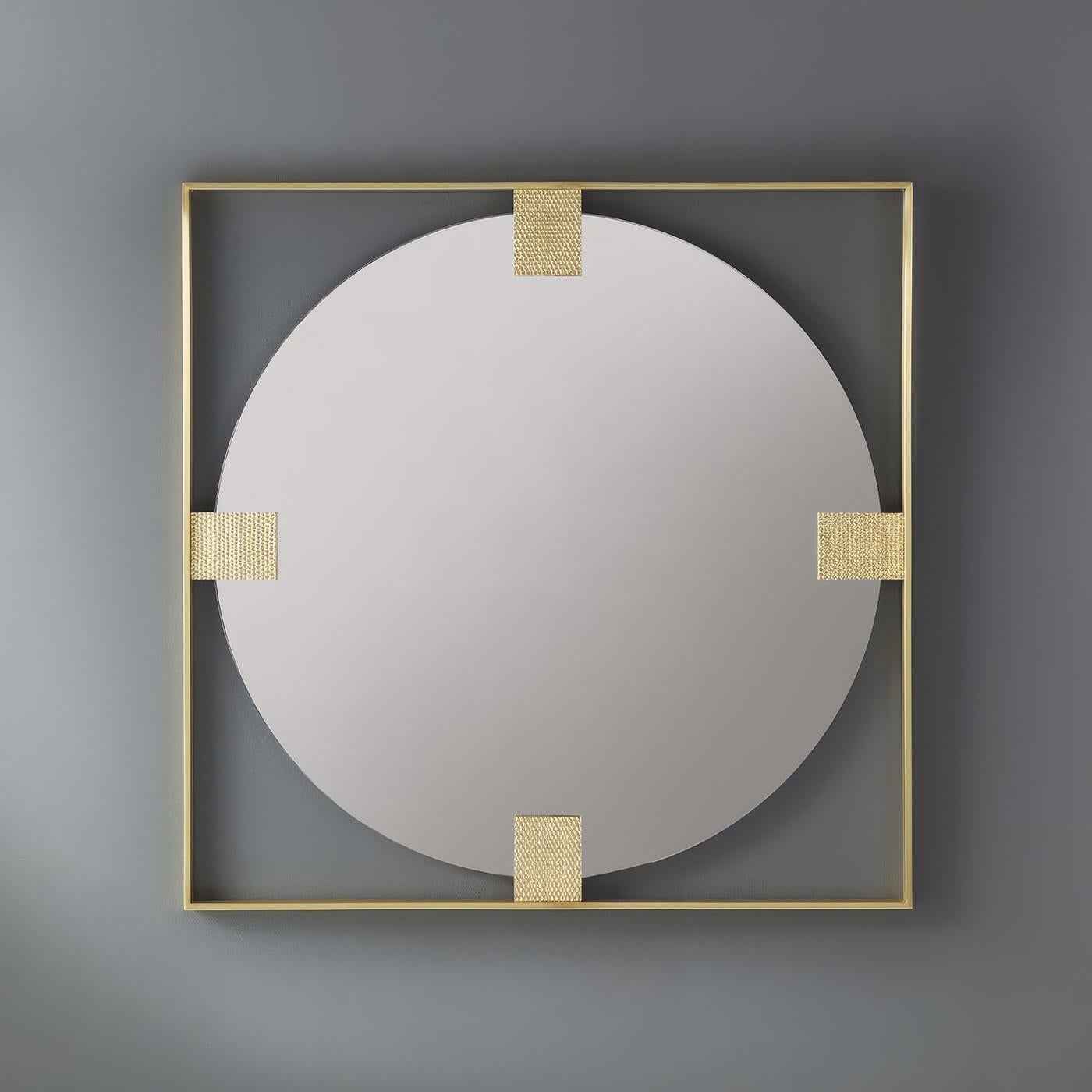 Questo squisito pezzo presenta un elegante specchio circolare incorniciato e fluttuante all'interno di un'audace struttura quadrata, creando un contrasto sorprendente che incarna l'eleganza moderna.  Gli accenti in ottone testurizzato introducono un