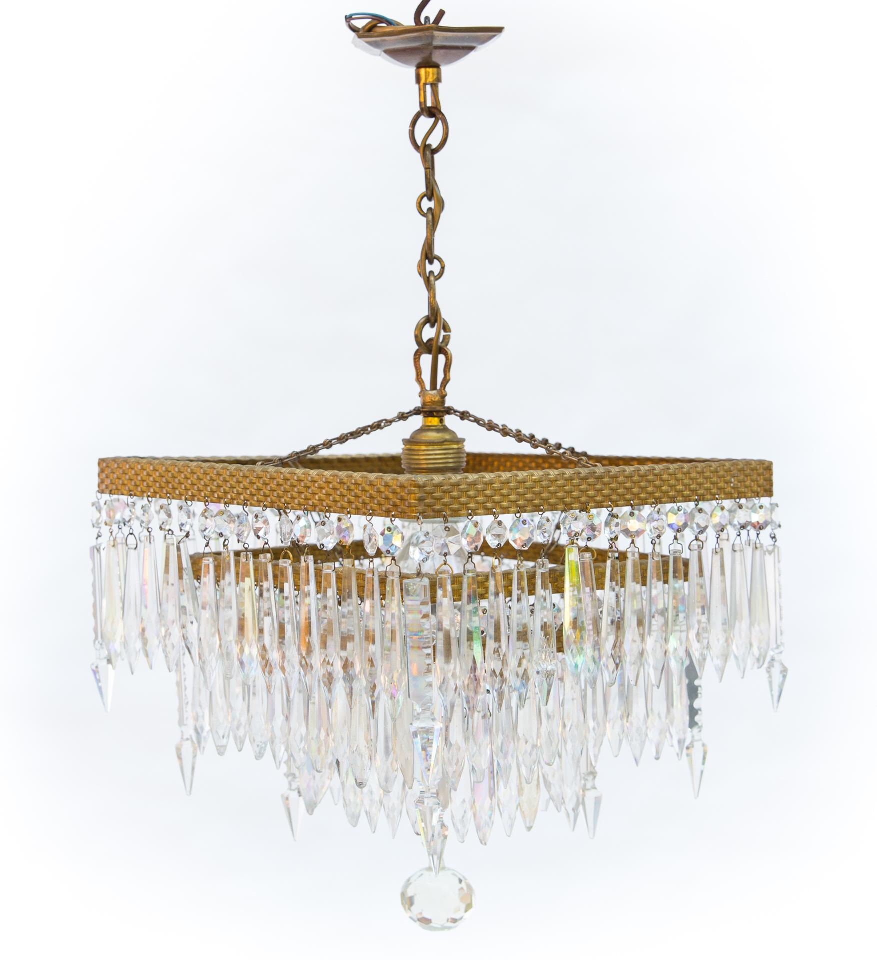 A very interesting and unusual crystal chandelier based on square hoops. Hoops made of a beautiful metal strip, pressed into concave convex braid.

The slats have original, beautiful gilding. Three floors create a dense curtain of crystal, antique