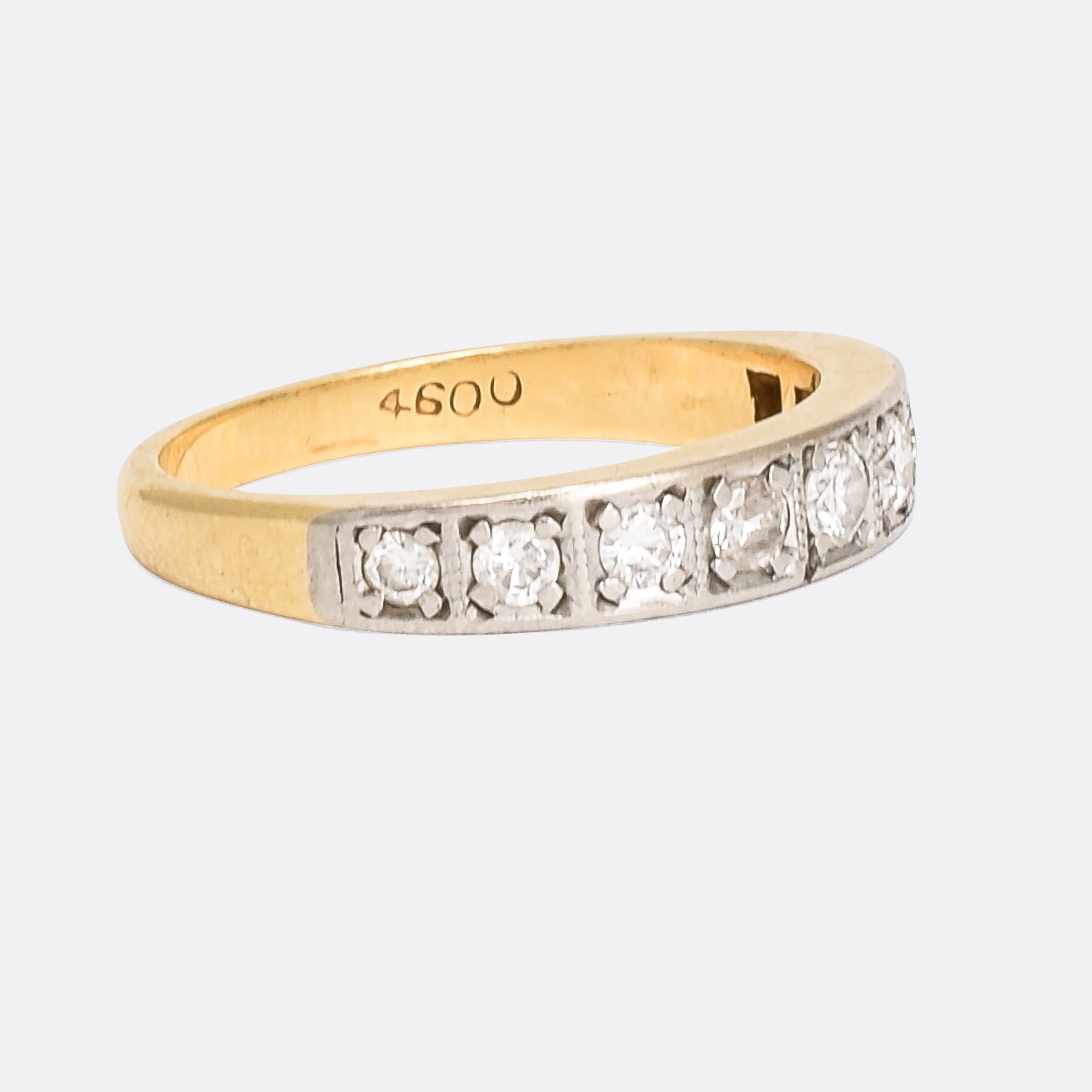 An Art Deco era half eternity ring dating from 1930s England, and set with just under half a carat of graduated brilliant cut diamonds. The stones rest in individual square platinum mounts, decorated with a hint of millegrain and tapering down