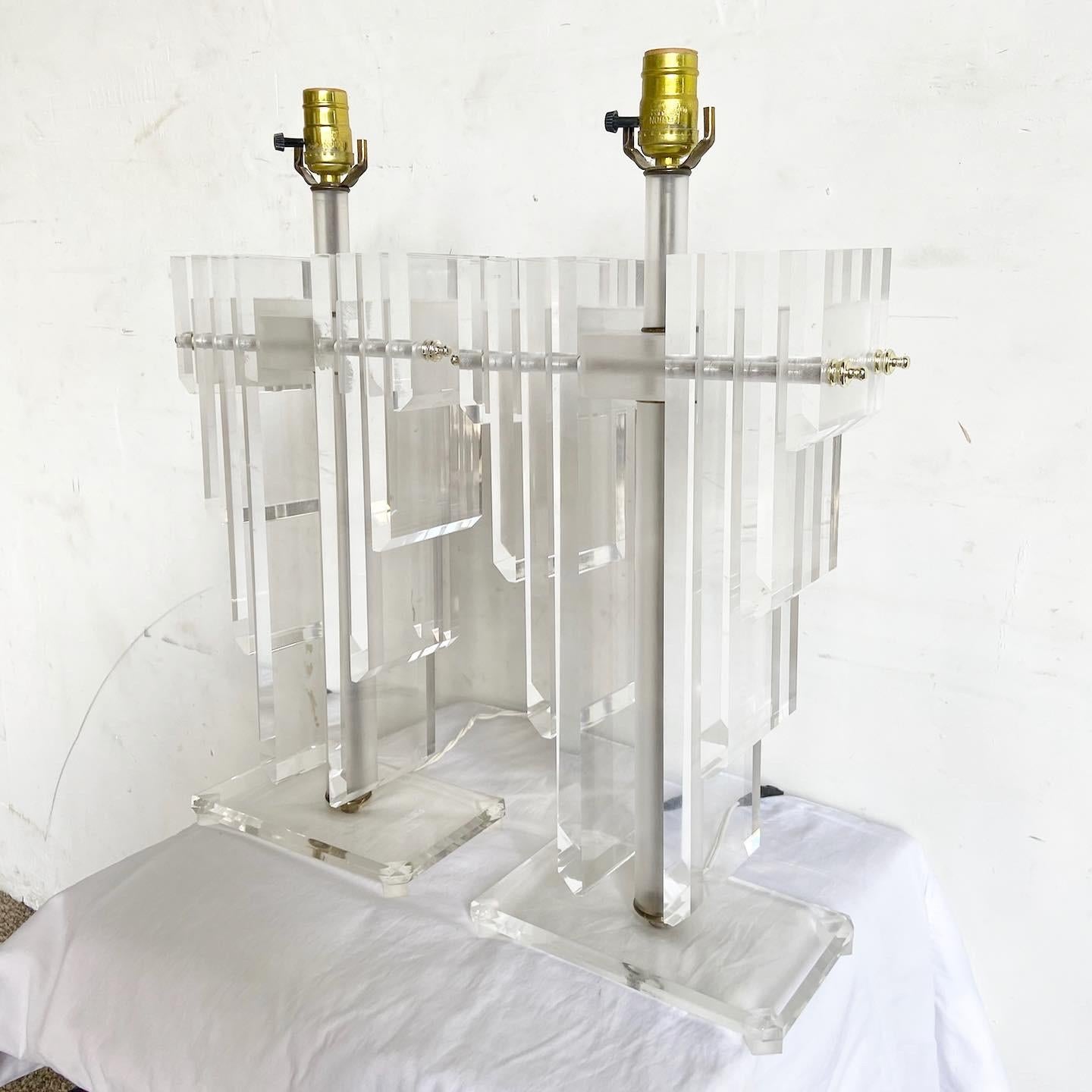 Step back in time with this pair of Art Deco Lucite Lamp Pair. Their unique design, reminiscent of angel wings, captures the essence of the Art Deco era. Assembled Lucite chunks create a mesmerizing play of light and reflection, making these lamps