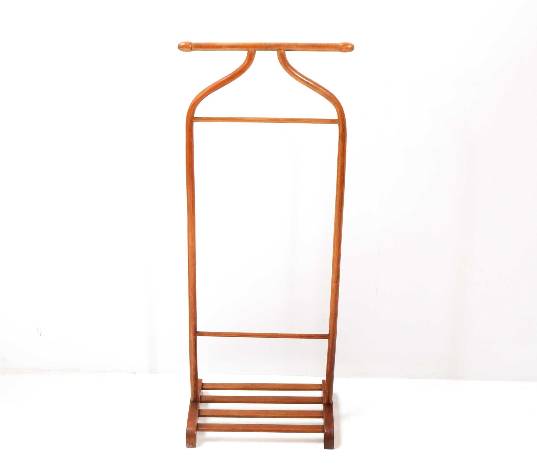 Elegant and sleek Art Deco valet stand or coat rack.
Design and executed by Thonet Vienna.
Striking Austrian design from the 1920s.
Bentwood beech frame with two racks and one rail for hanging clothes and
a storage space with wooden slats for