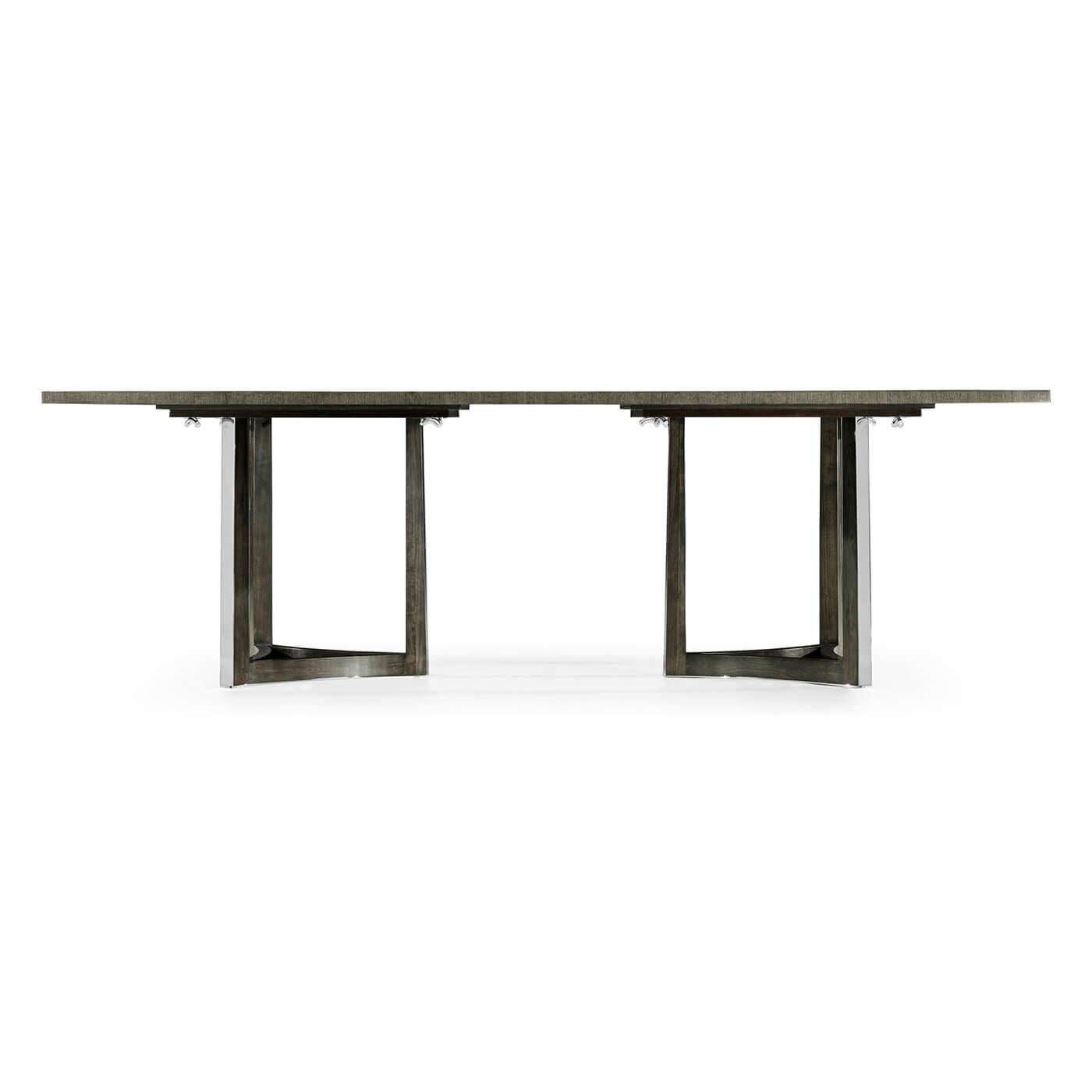 An Art Deco inspired dining table with an unusual Eucalyptus veneered patterned stop with cross banding and raised in two tripartite stainless steel pedestals.

Dimensions: 84