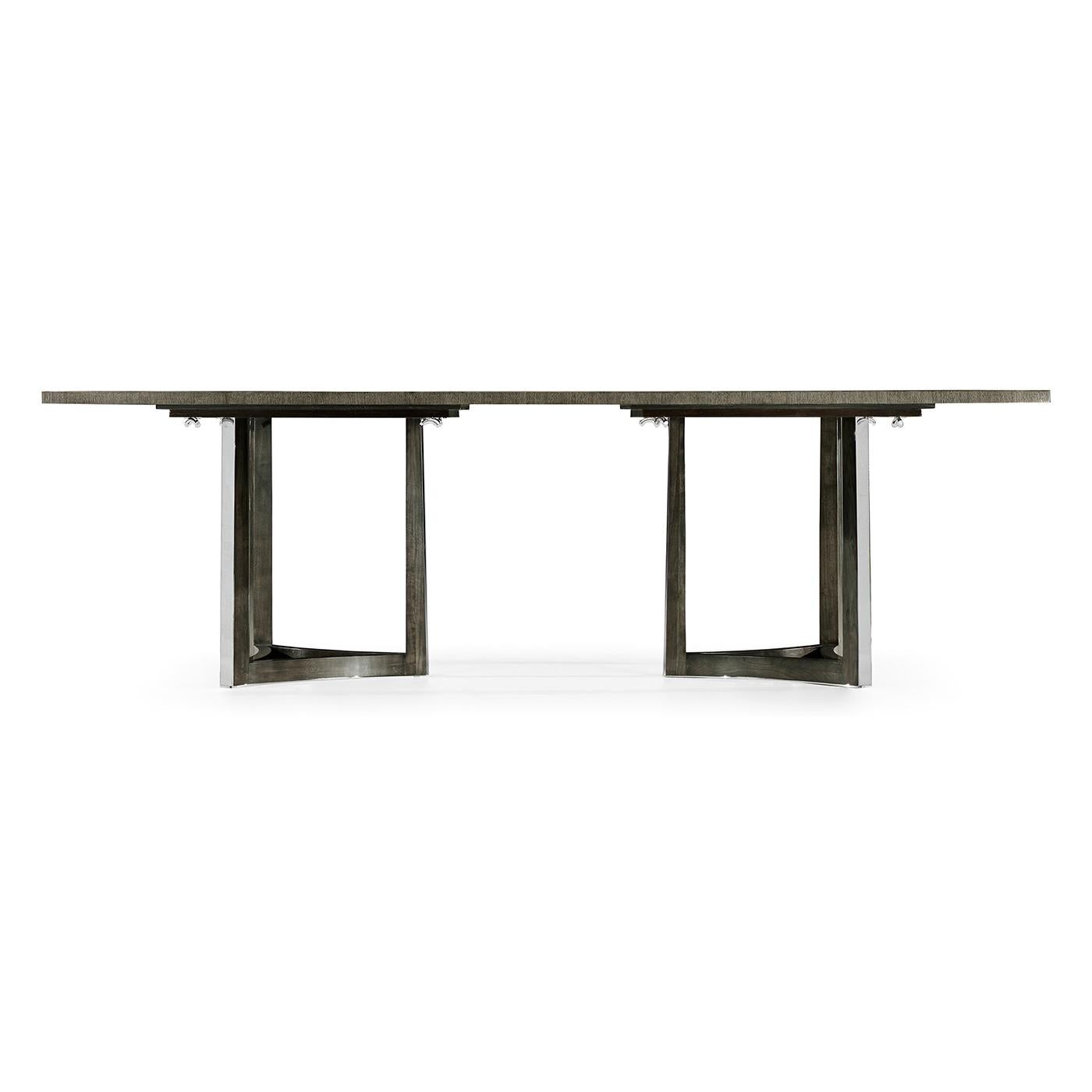 An Art Deco inspired dining table with an unusual Eucalyptus veneered patterned stop with cross banding and raised in two tripartite stainless steel pedestals.

Dimensions: 108