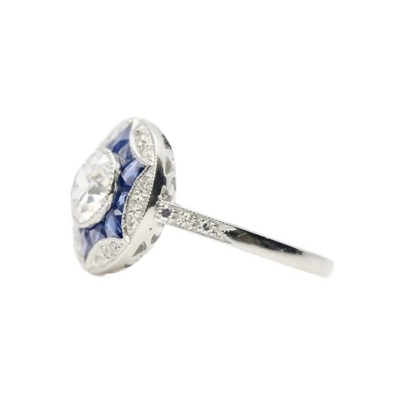 An Art Deco style old European cut diamond, and French cut sapphire star form ring in platinum.

Centered by a 0.85 carat H color, VS2 clarity old European cut diamond resting in a milligrained platinum bezel.

Framed by bespoke French cut sapphires