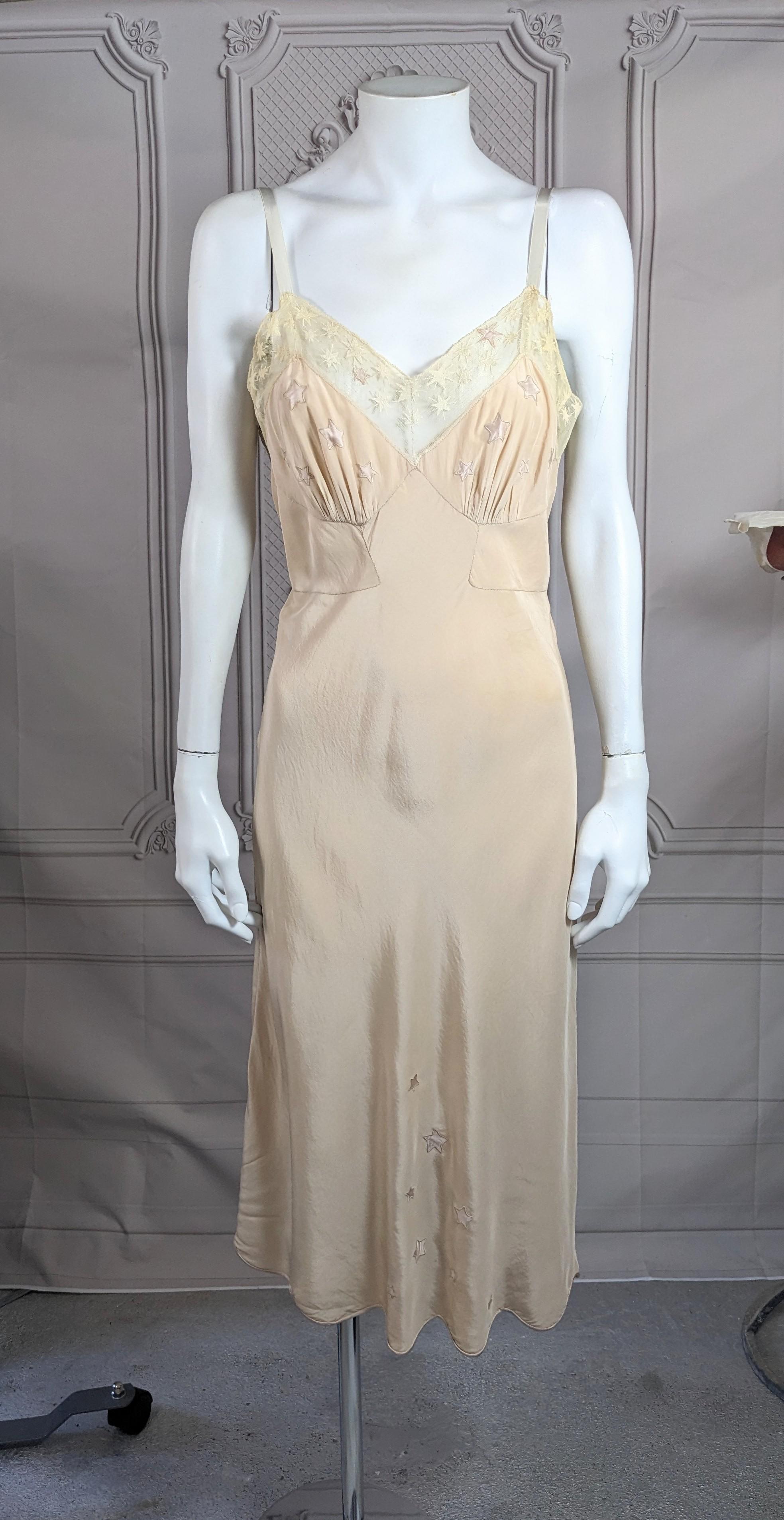 Bergdorf Goodman labeled Art Deco  star motif bias slip dress of pinky taupe colored silk crepe with ivory cotton star tulle and embroidered/appliqued satin stars decorating the bodice and hem. Satin bias trimmed scalloped edge. Good condition,