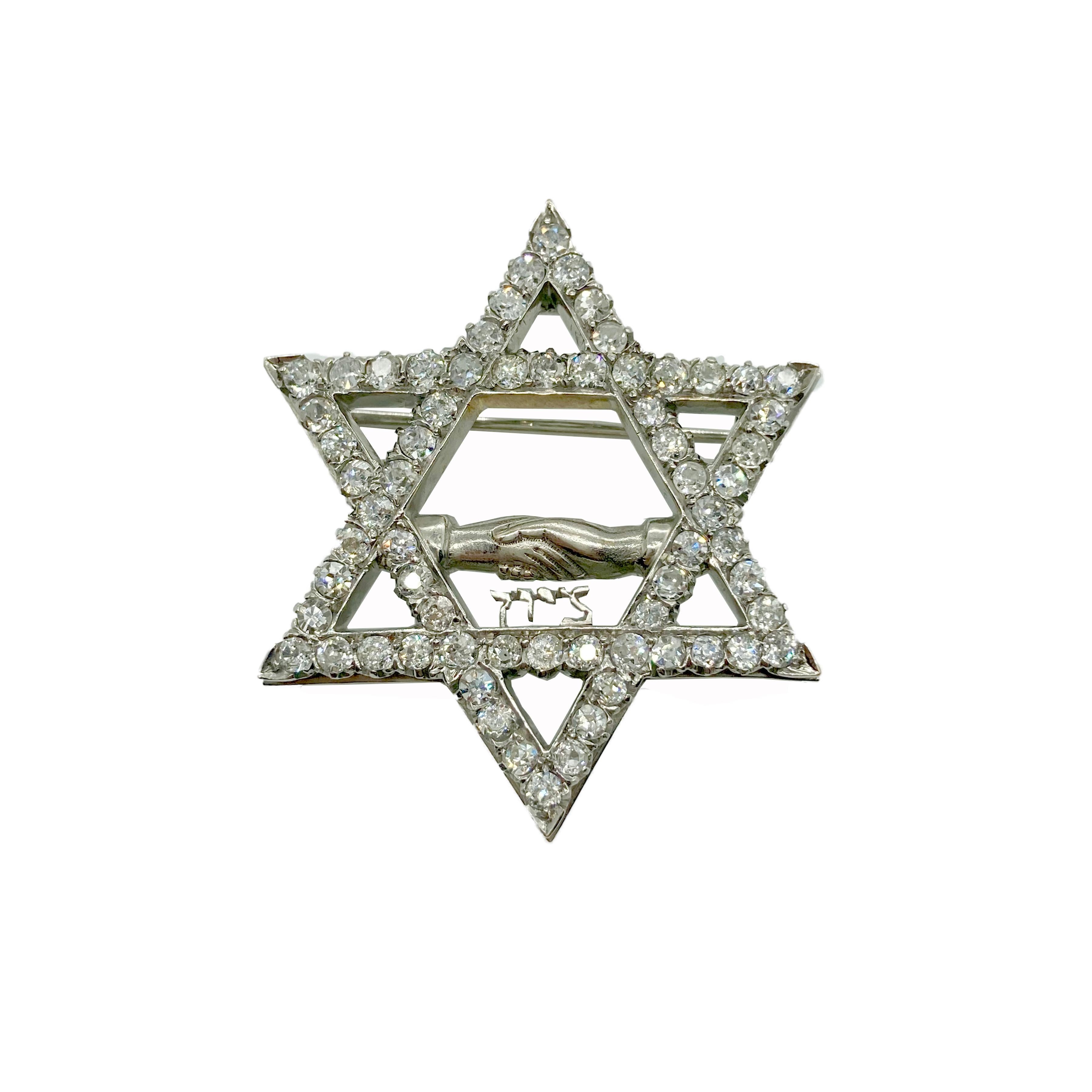 A stunning Star of David white gold brooch with 6 carats of old cut diamonds. With a Hebrew inscription reading “Zion”. Circa 1920s.