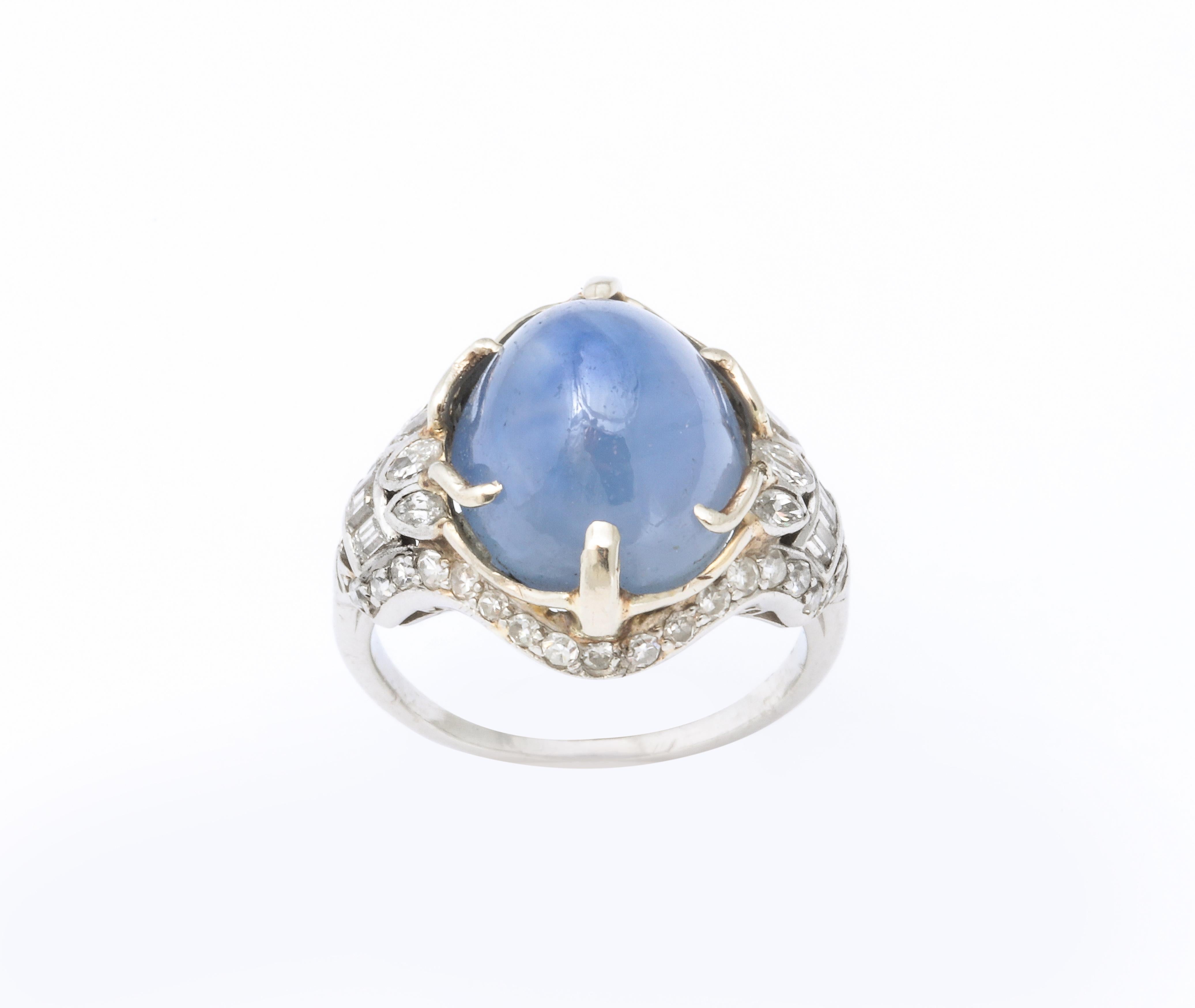 A wonderful  French Art Deco natural un heated cabochon 12.50 Cts Star Sapphire surrounded by mine cut combination of square cuts and marquis diamonds and baguettes set in Platinum. Appraisal available.
