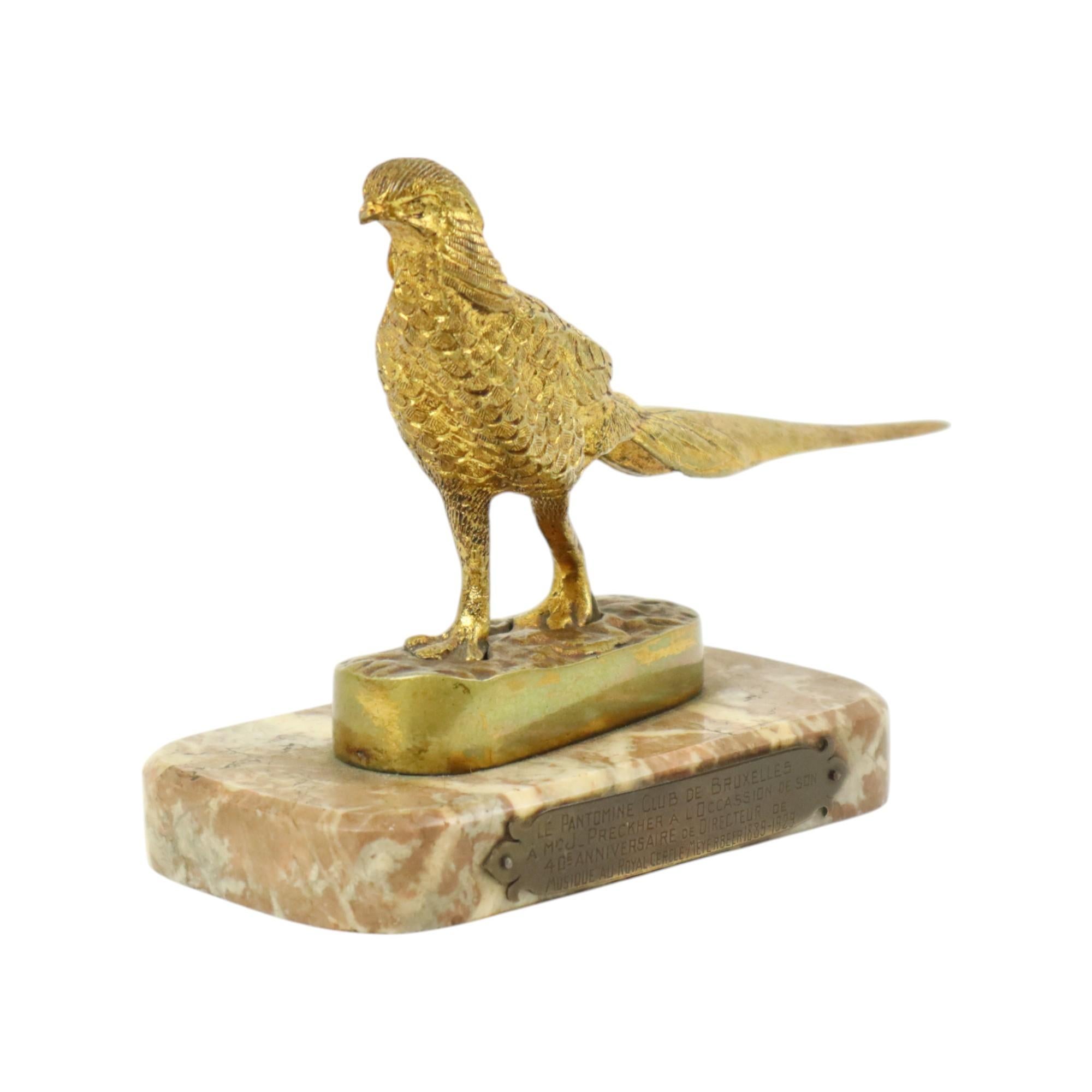 Statuetta art déco, scultura di un fagiano in bronzo dorato a foglia d'oro, completamente in stile art déco, montata su una base arrotondata in marmo rosso, alla base una targhetta con iscrizione, datata 1929, la statuetta è forse molto più antica