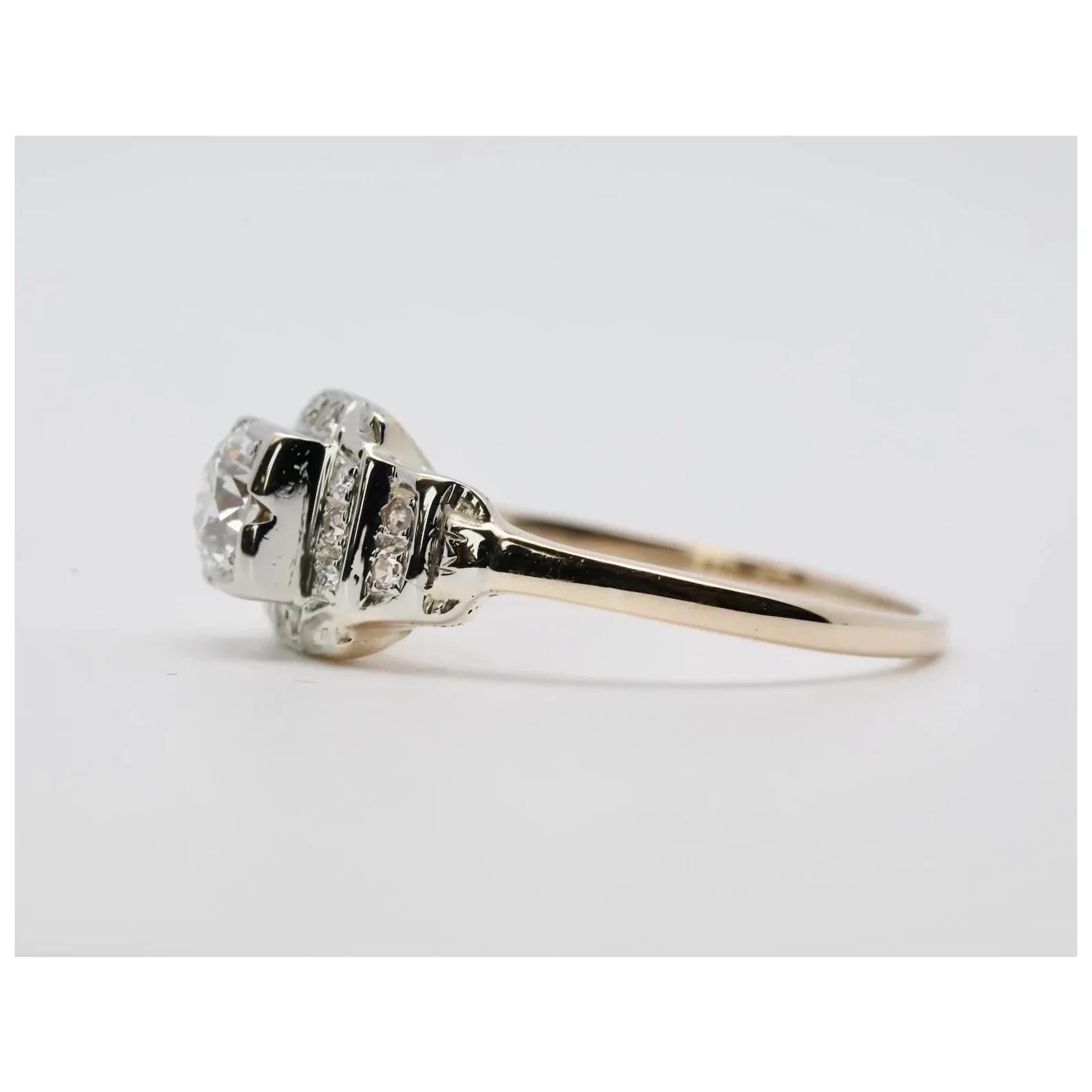 A late Art Deco period stepped style diamond engagement ring. Crafted in two tone 14 karat white, and yellow gold this ring is centered by a European cut diamond accented by Pave set diamonds. The center diamond weighs 0.50 carats and grades as H