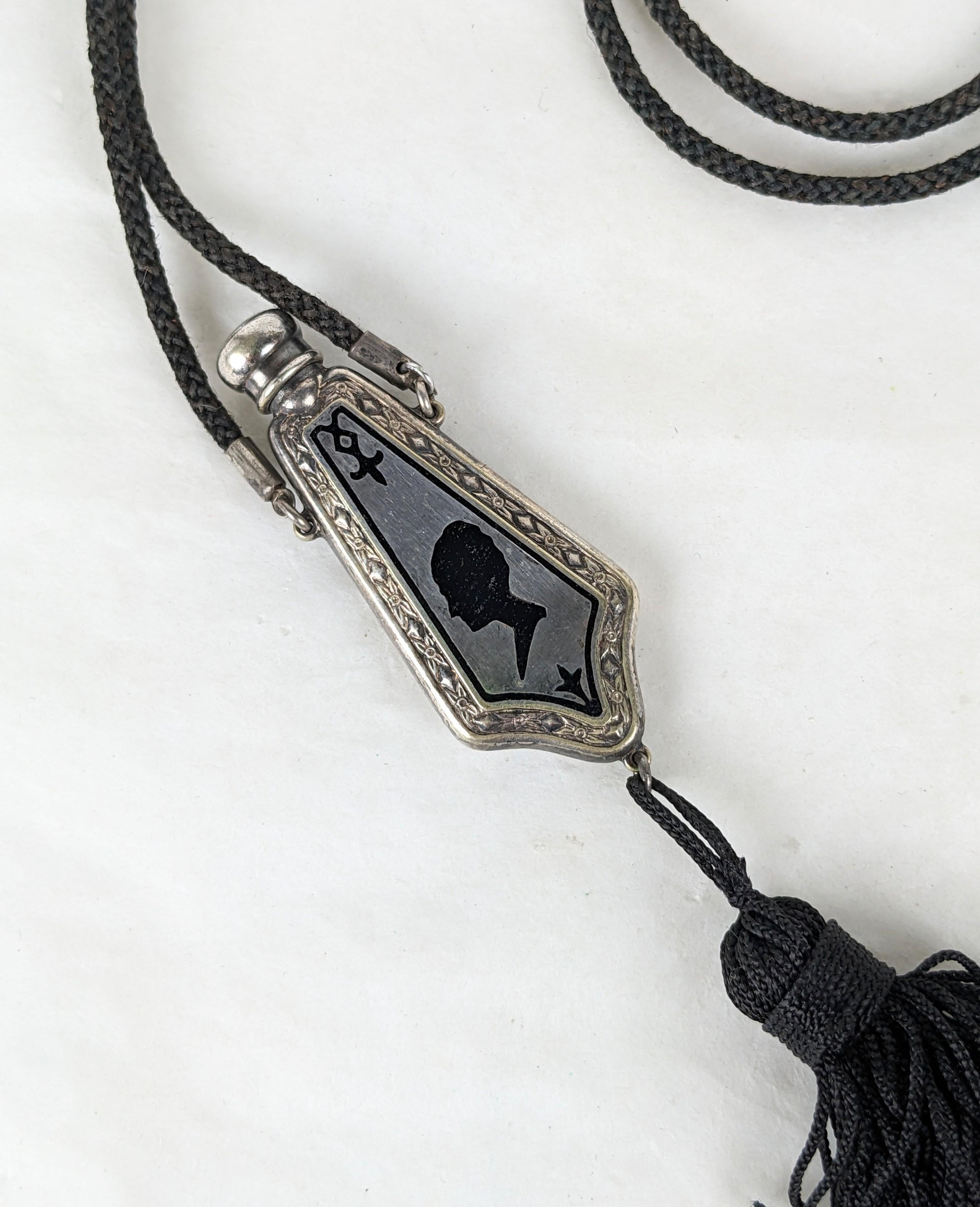 Charming Art Deco Sterling Enamel Perfume Pendant from the 1920's. Enamel flapper profile in black on sterling vial with twist off top and dabber. Cotton cord necklace with filigree slider and silk tassel. 1920's USA. 30