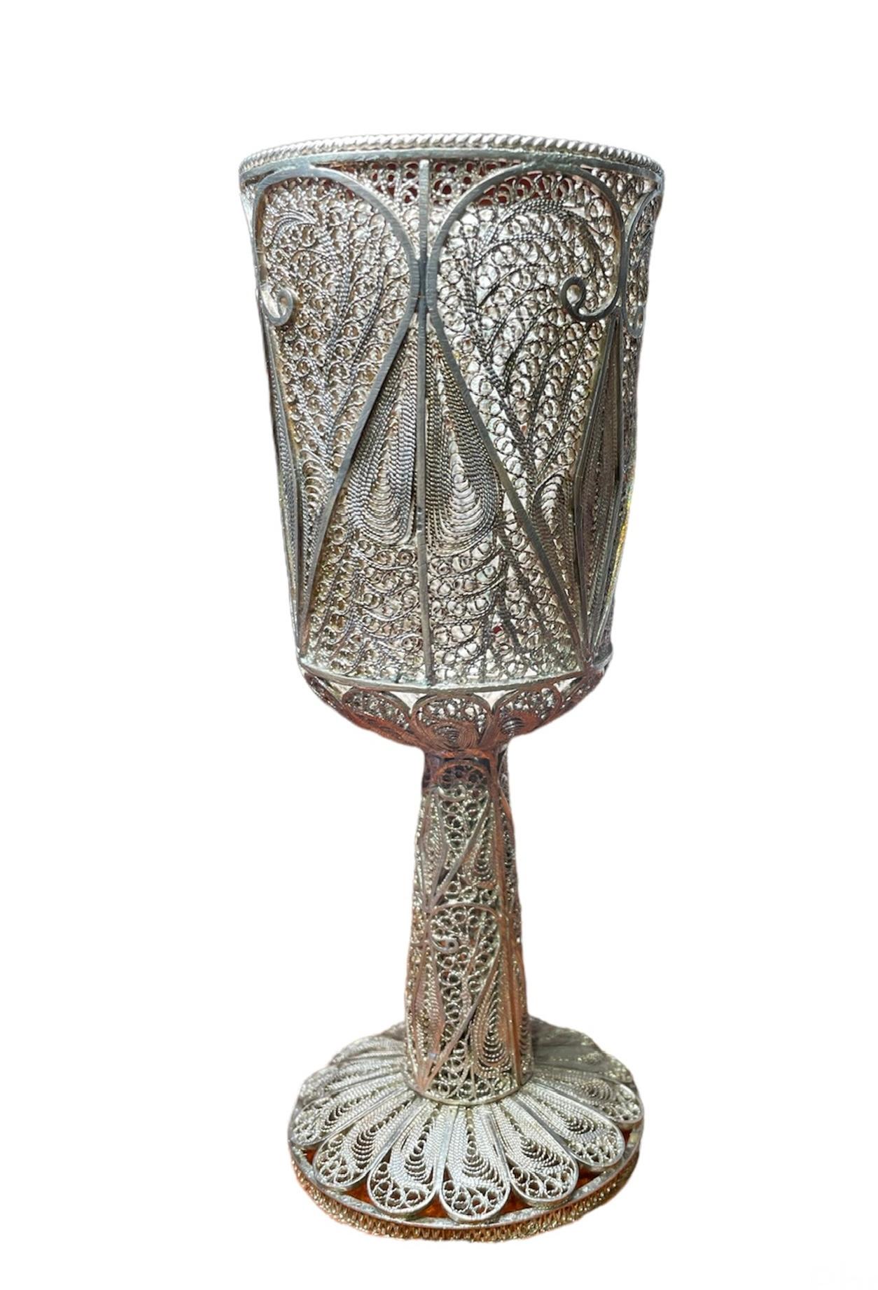 This is a silver 925 filigree cup/goblet. It is entirely decorated with very well done filigree work. There are large sizes of hearts and long diamonds adorning the bowl part of the cup and smaller ones doing the same at the stem. The bottom of the