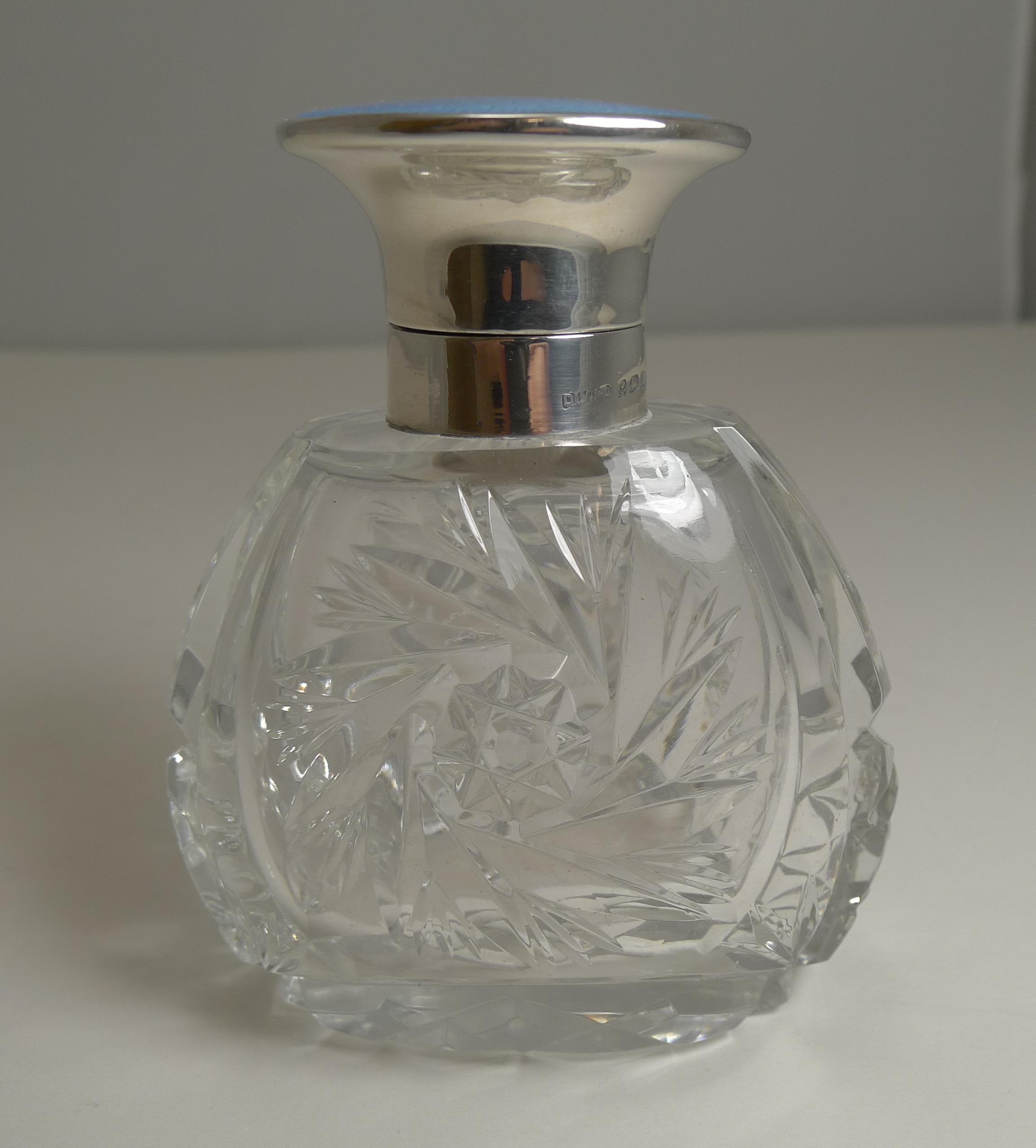 A beautiful perfume or scent bottle made from a heavy piece of English crystal intricately handcut in a variety of designs.

The collar and hinged lid is made from English sterling silver fully hallmarked for Birmingham 1934 together with the