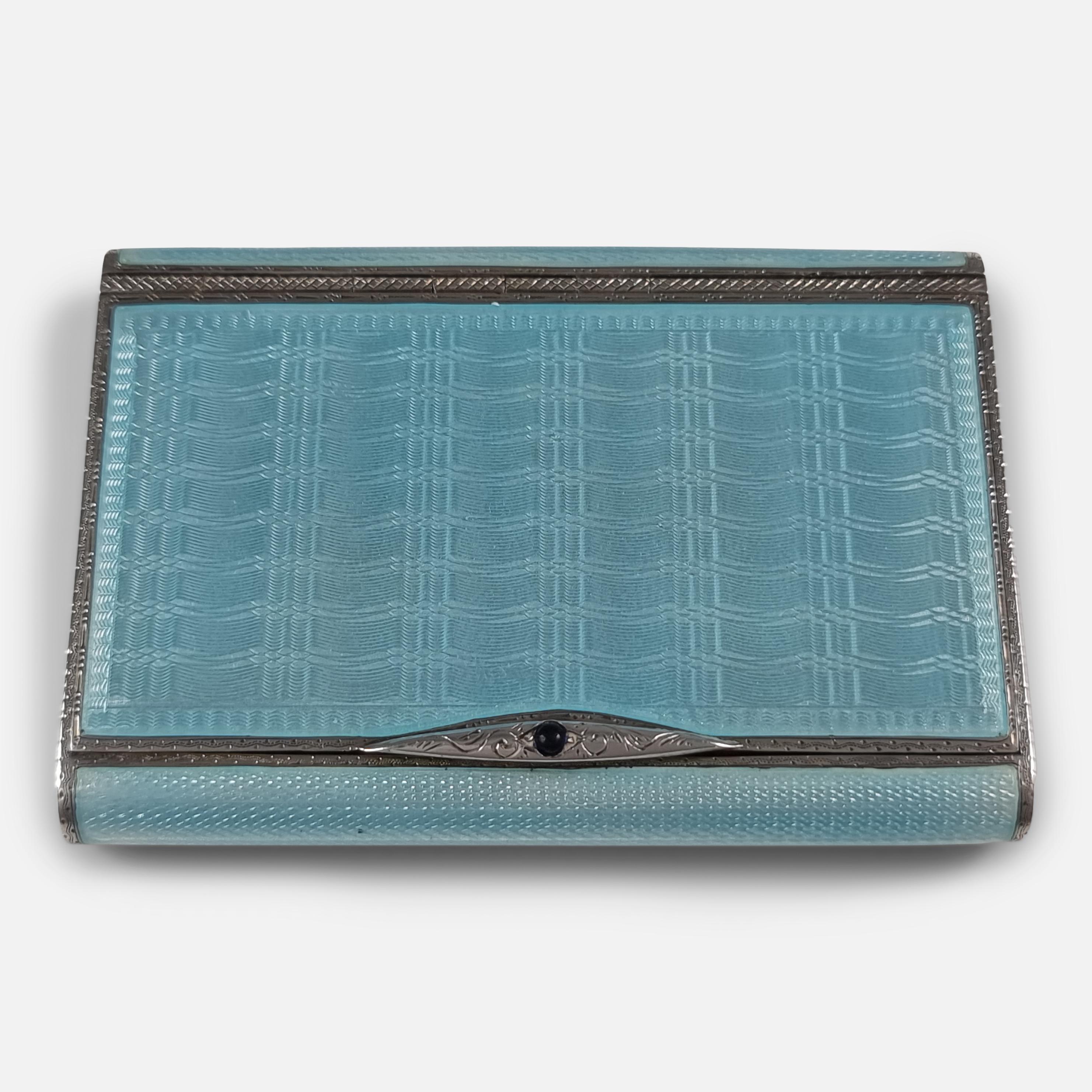 An Art Deco sterling silver and enamel cigarette case. The vintage silver cigarette case is of rectangular form, with light blue guilloche enamel decoration, engraved borders, blue cabochon thumbpiece, and hinged lid leading to a gilded