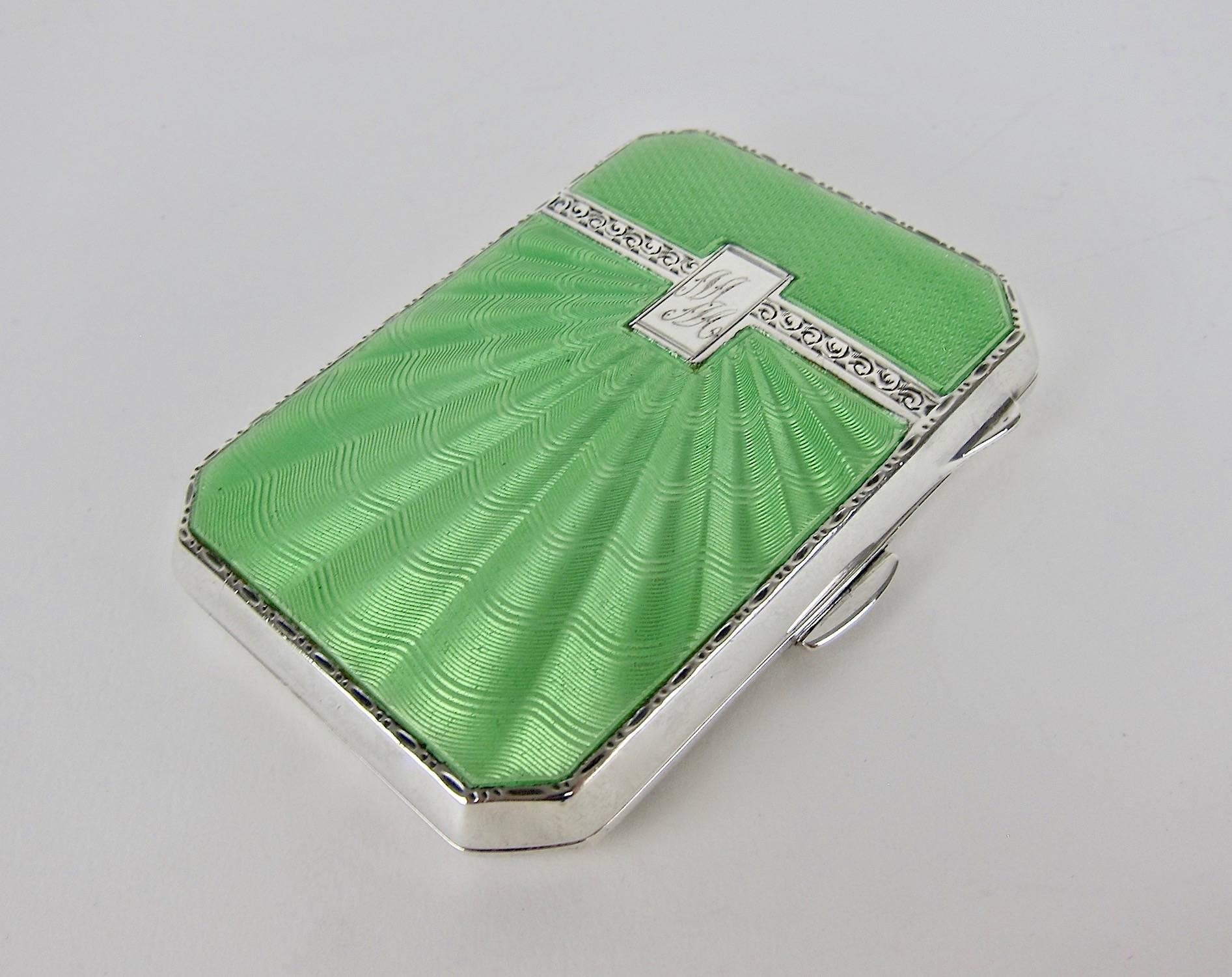 An English Art Deco ladies cigarette case in sterling silver and apple green enamel by Joseph Gloster Ltd., Lion Silver Works, Hockley Hill, Birmingham. The top of the vintage case is decorated with two fields of guilloche enamel separated by a