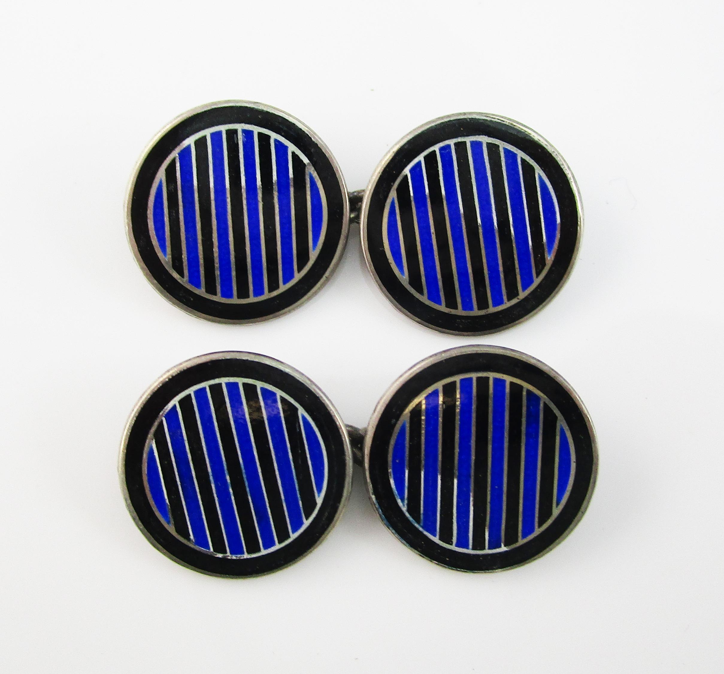 These great Deco cufflinks are in sterling silver and feature a classic round design decorated with black and blue enamel. The panels feature a black enamel frame that is filled with alternating black and blue stripes. This classic color combination