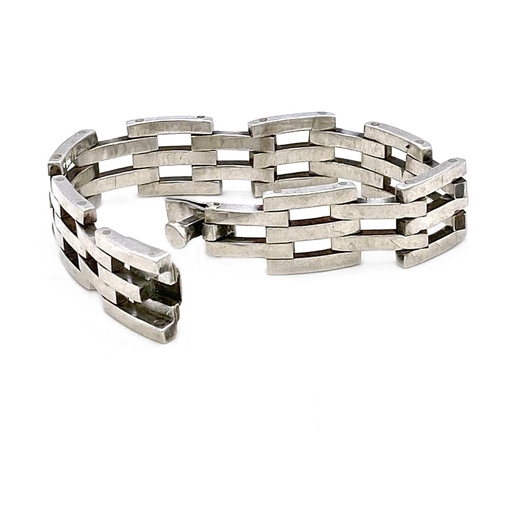 This is an Art Deco style sterling silver bracelet. It has rivited industrial looking segments with a box clasp. Sometimes called a tennis bracelet. Marked TP-81 925 Mexico on the inside surface.

Our vintage jewelry collection and original