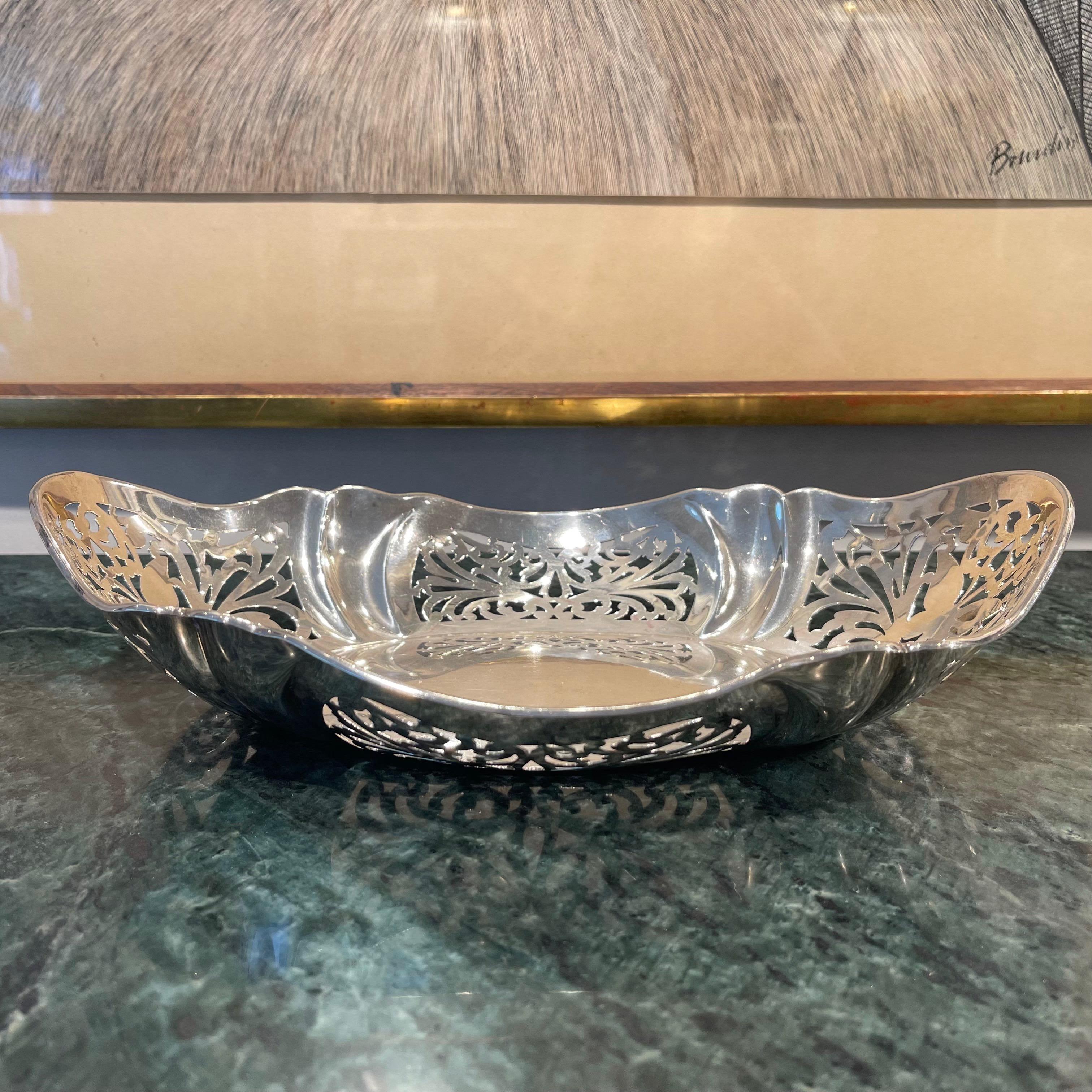 An ornate and decorative Sterling Silver breadbasket, hallmarked to the company of R F Mosley & Co, Sheffield, 1926. The intricate, symmetrical cut-out designs to the sides reveal motifs of butterflies and arabesques that complement the curved