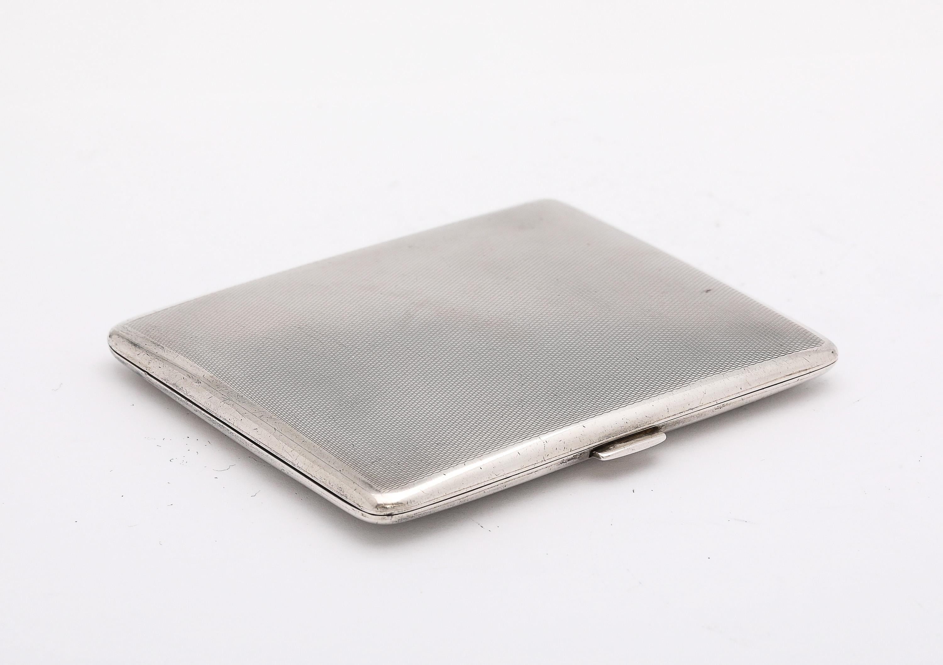 Art Deco Period, sterling silver, hinged cigarette case, London, year-hallmarked for 1931, Goldsmiths and Silversmiths (located at 112 Regent Street West, London) - makers. The cigarette case is engine-turned in design. The cigarette case measures 3