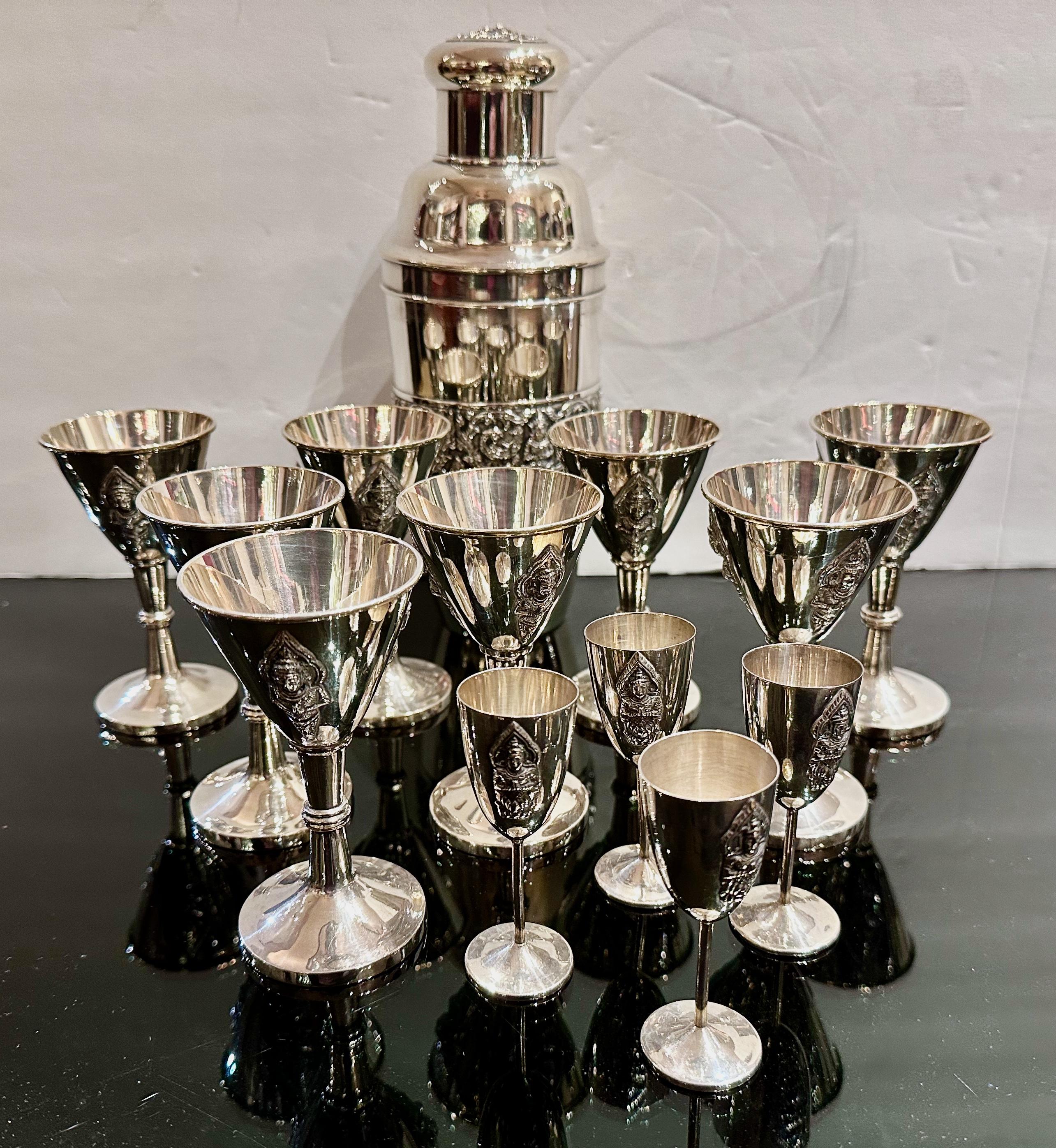 This exceptional cocktail shaker set, marked “Alex and Co Sterling 950,” comprises a shaker and 12 glasses, all in excellent condition. Crafted in Siam (now Thailand) from sterling silver, the set is a testament to exquisite craftsmanship. Adorned