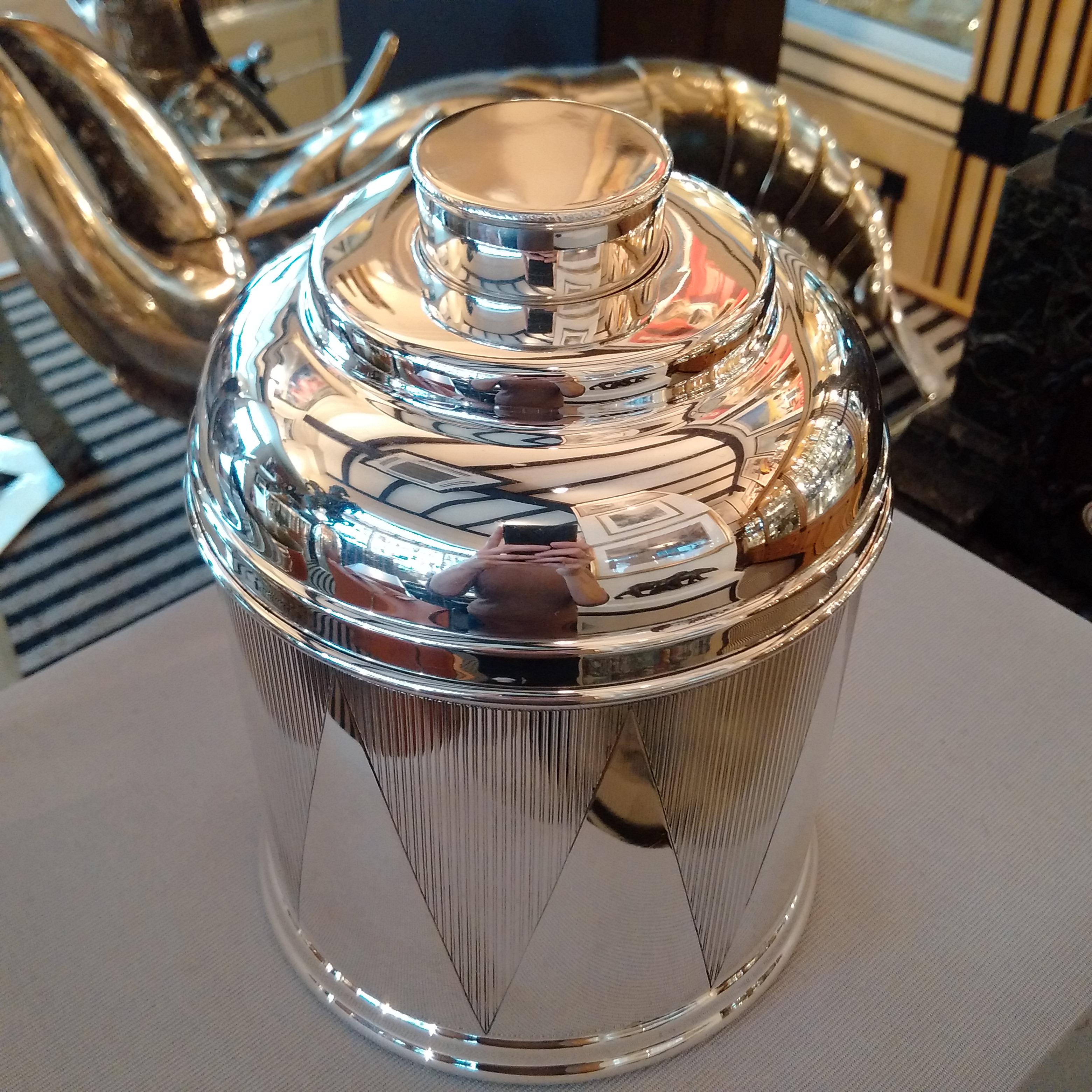 Humidor Corporation of New York City, an incredibly stylish Sterling silver cigar humidor of drum form, the straight-sided body with deep geometric Art Deco engraving to the sides, with a rolled foot. The curved neck of the lid with a pull-off