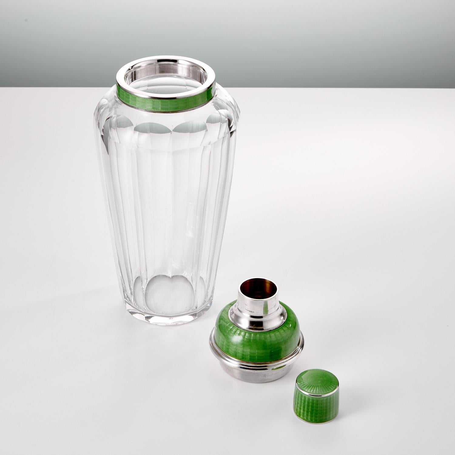 Art Deco sterling silver & enamel cocktail Shaker Date Circa 1930-35.

A beautiful rare silver and enamel cocktail Shaker with a tapered segmented glass form body. The 'Apple Green' coloured enamel is in superb quality with good translucent glaze
