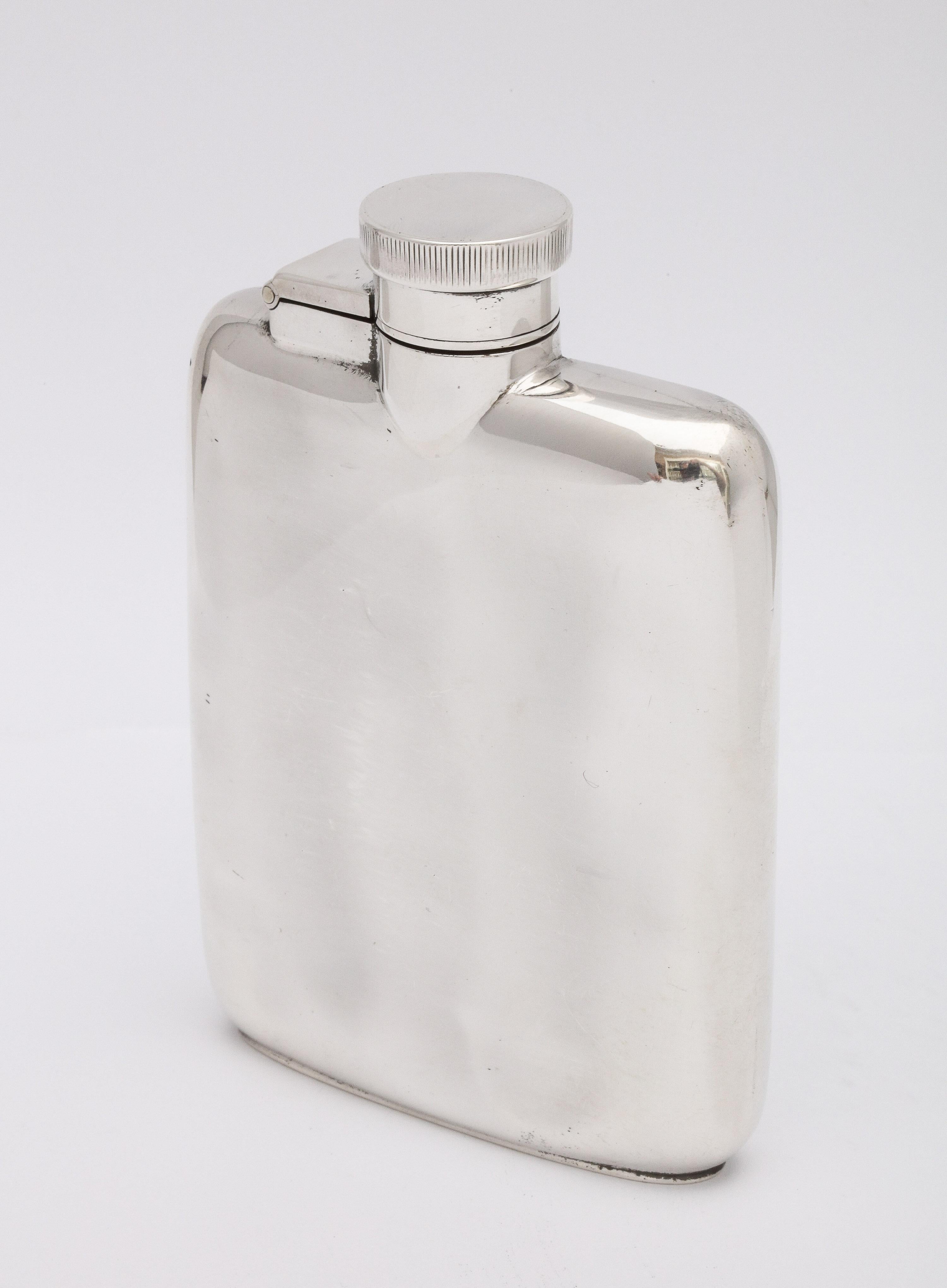Art Deco, sterling silver flask with hinged lid, Chester, England, Robert William Jay - maker. Measures: 4 1/4 inches high x 2 3/4 inches wide (at widest point) x 3/4 inches deep. Weighs 3.515 troy ounces. Hinged lid has bayonet closure. Dark spots