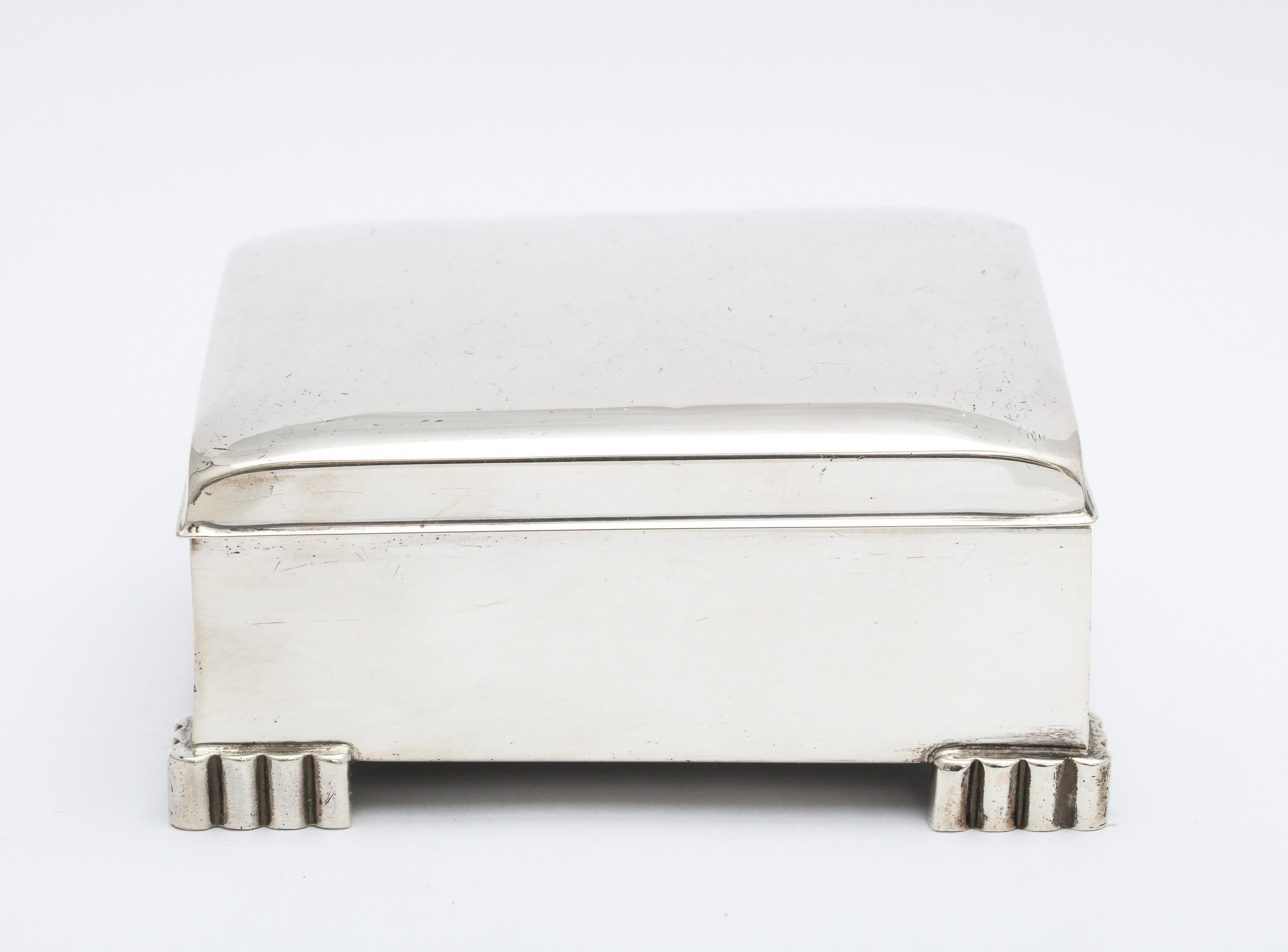 Art Deco, sterling silver table box with hinged lid. Poole Silver Co., Taunton, Mass., circa 1930s. Measures 4 inches wide (from foot to foot) x 3 1/2 inches deep (from foot to foot) x 1 1/2 inches high. Wood lined. One very tiny dint in upper right