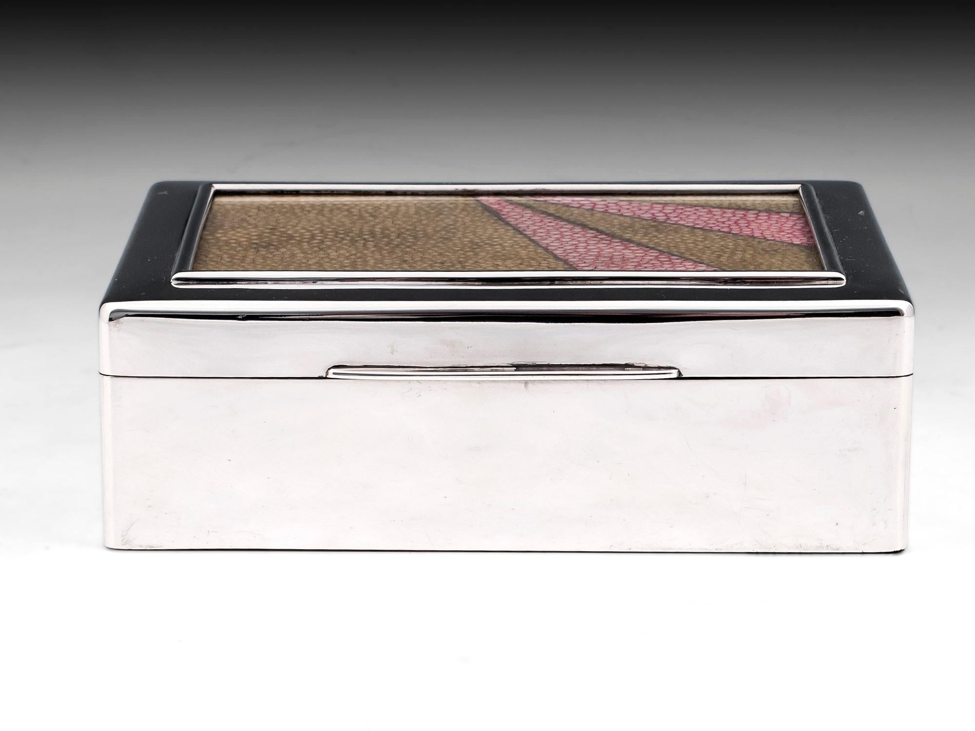 Sterling silver cigar box with pink and green shagreen glazed panel on the lid.
The interior is lined with satin cedar wood with a removable compartment divider.
By London Silversmith John Septimus Beresford, 1913.
