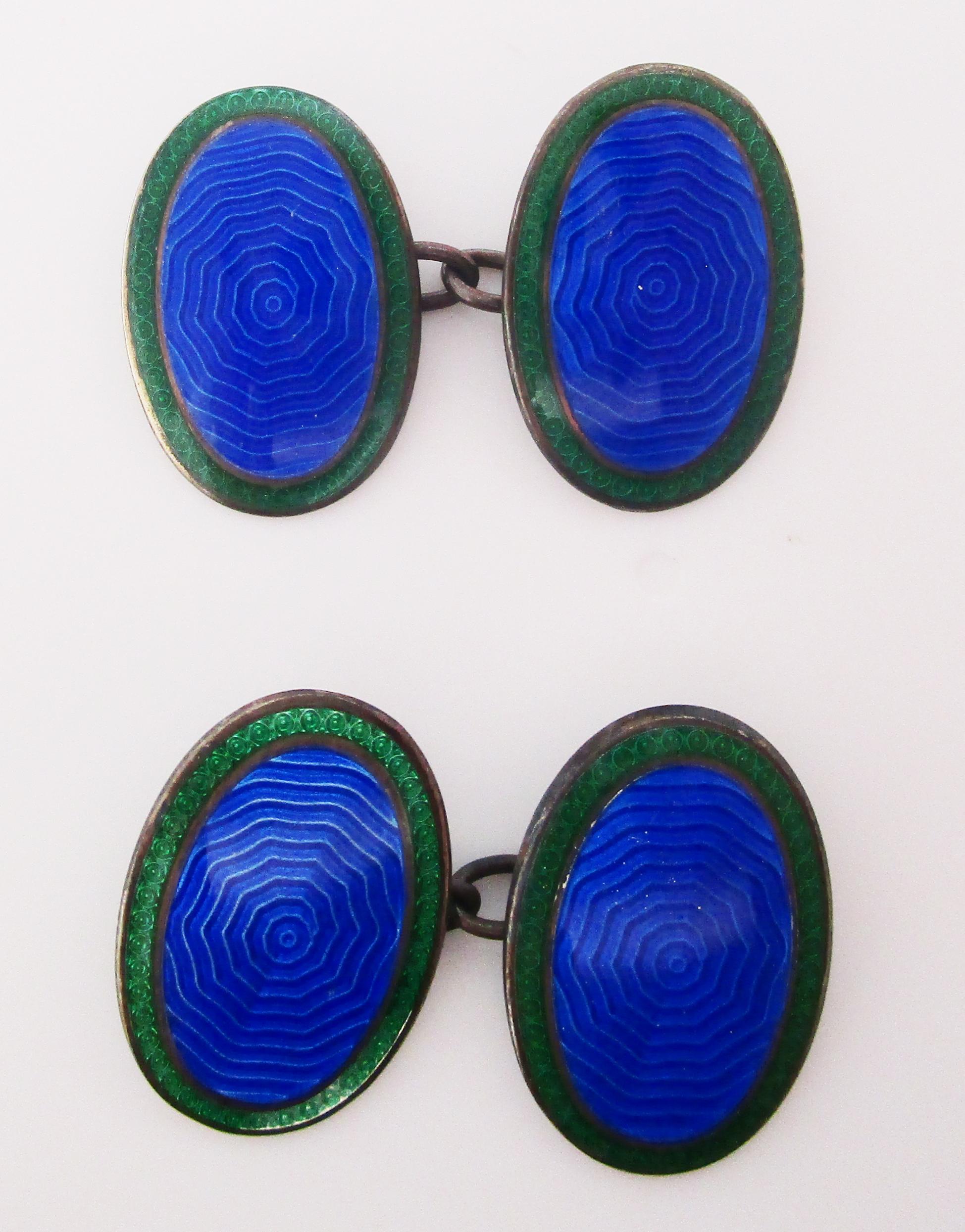This stunning pair of Art Deco links is in sterling silver and features bright blue guilloche enamel centers and rich green enamel borders. The enamel center features a subtle concentric circle pattern that adds a layer of intrigue to this classic