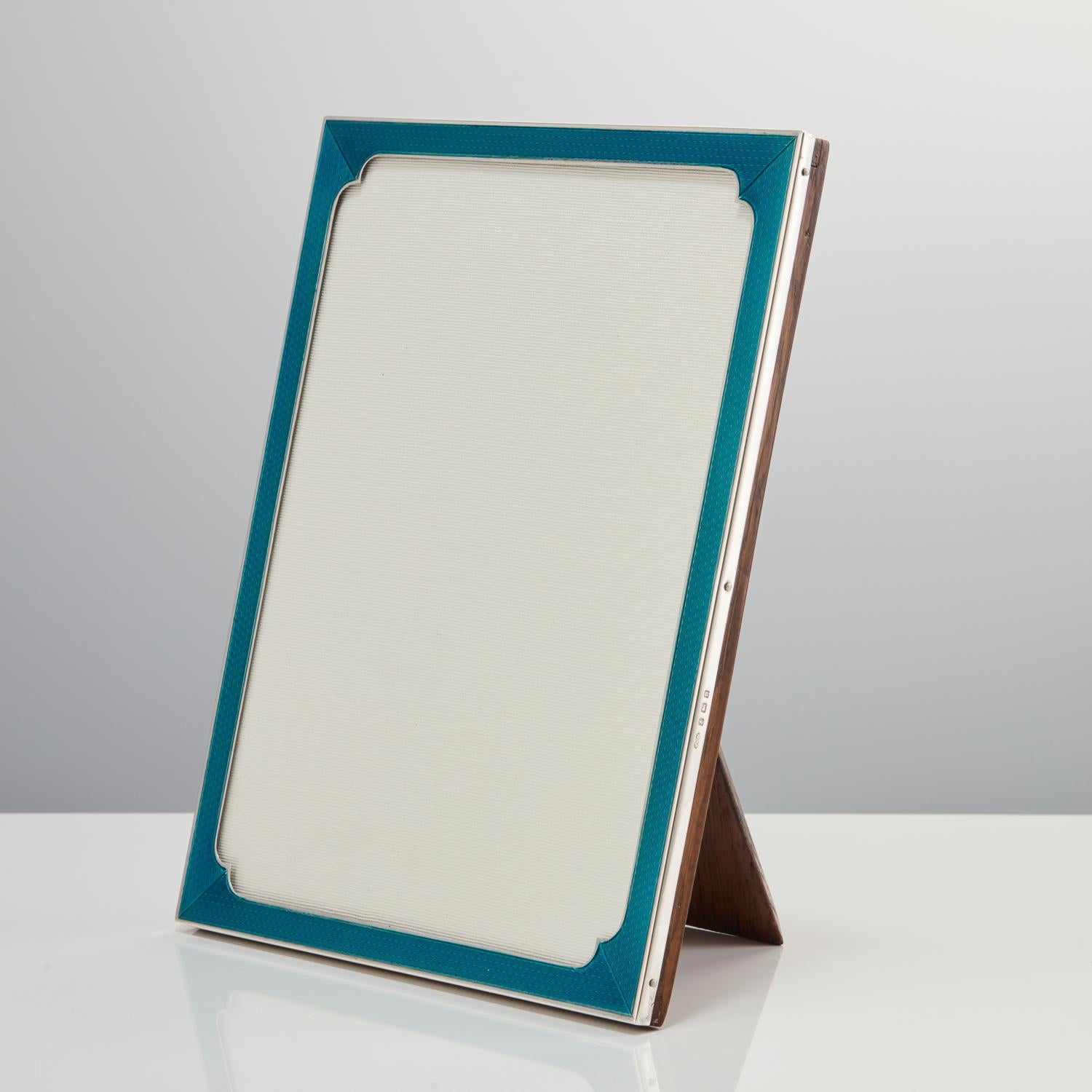 This is a beautiful and rare large Art Deco sterling silver & guilloche enamel photo frame by Sanders & Mckenzie Date Birmingham 1926.

A great quality frame in this distinctive Aqua Marine colour. The shaping of the corners really sets it apart,