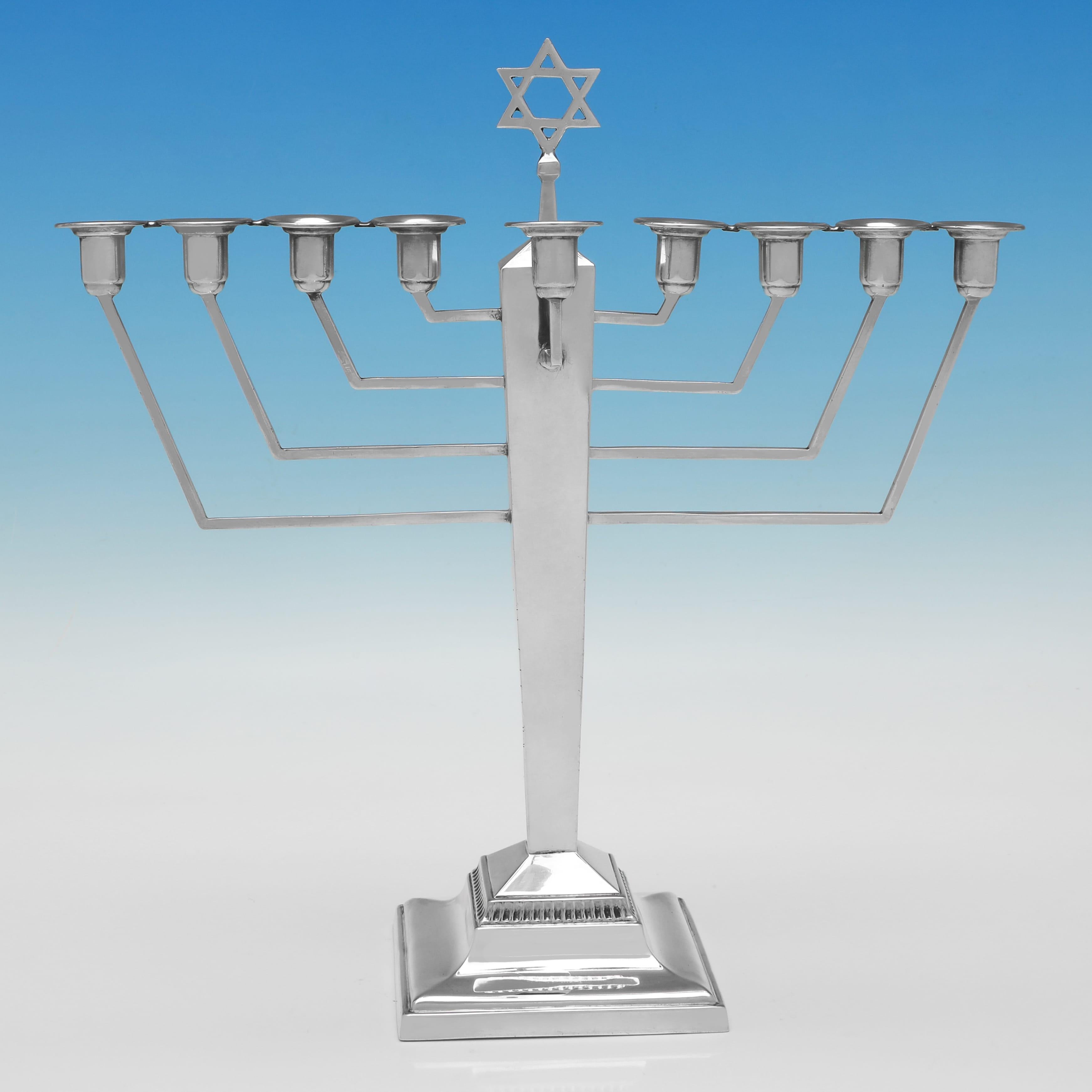 Hallmarked in Birmingham in 1938 by Britton, Gould & Co., this handsome, George VI, Sterling Silver Menorah, is in the art deco taste. The menorah measures 10.5