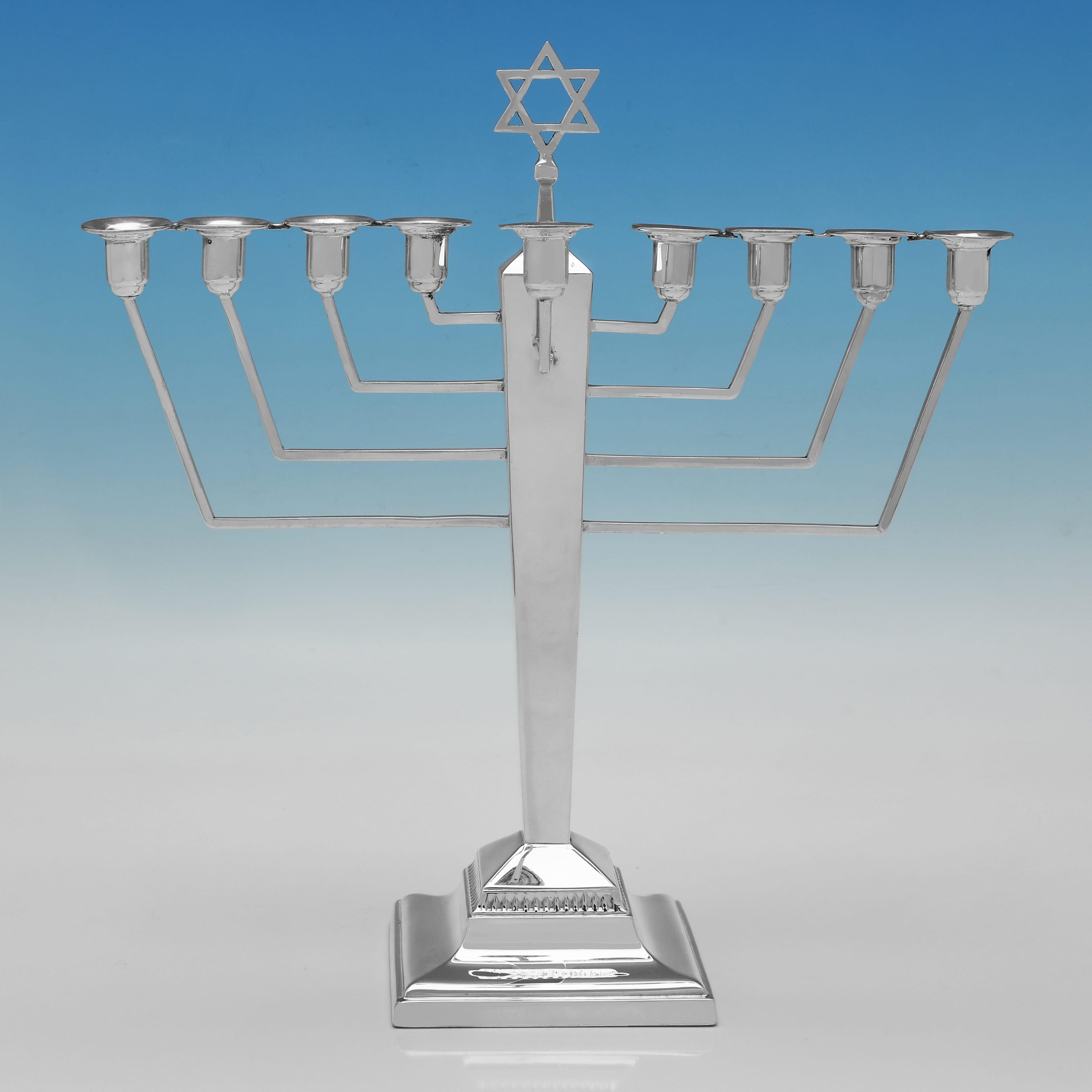 Hallmarked in Birmingham in 1939 by Britton, Gould & Co., this handsome, George VI, Sterling Silver Menorah, is in the art deco taste. The menorah measures 10.5
