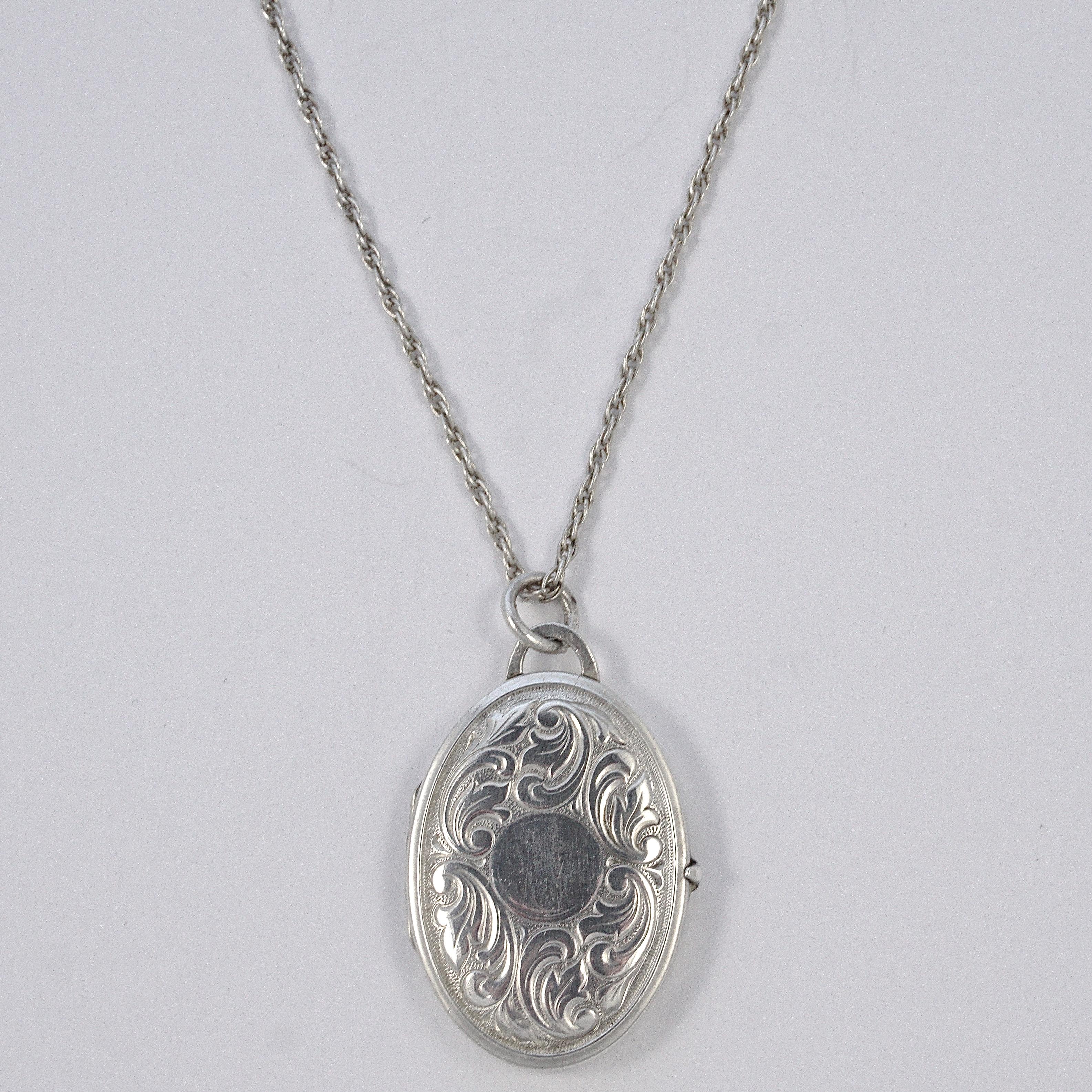 Beautiful Art Deco sterling silver oval opening locket and chain, featuring a lovely hand engraved leaf design to the front and an abstract design to the back. The front of the locket has space for an engraved initial. The oval locket measures 3.4cm