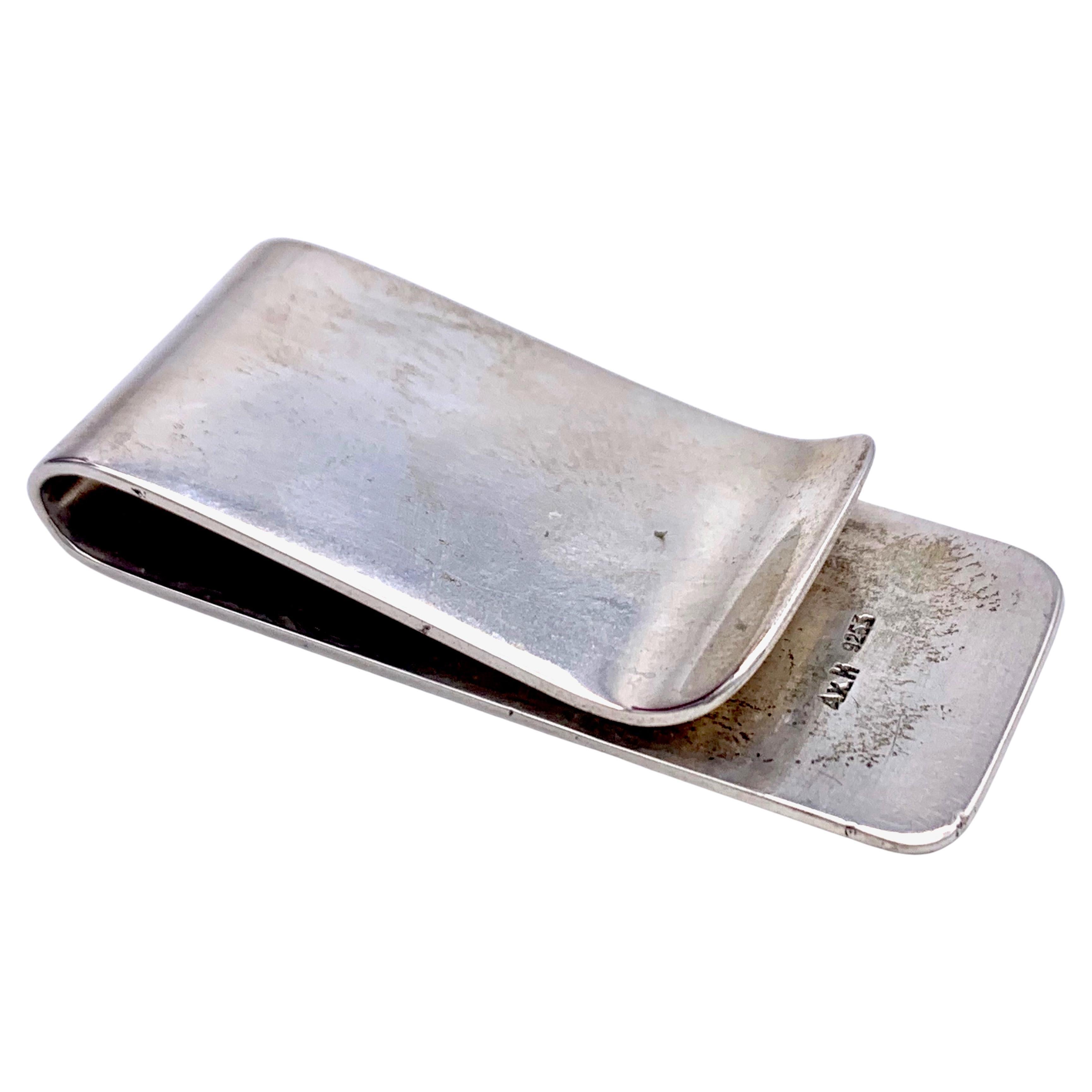 Esta elegante pinza para billetes de plata con grabado de diamantes se fabricó a mano en plata de ley en 1920 y lleva la marca 925.
El clip lleva estampadas las iniciales AxH.