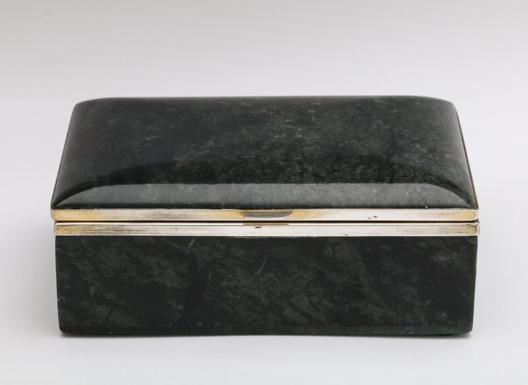 Art Deco, sterling silver-mounted dark green nephrite jade table box with hinged lid, Austria, circa 1920s. Maker's initials are CK. Hinged lid is gracefully curved. Measures: 5 inches wide x 1 3/4 inches high x 3 1/4 inches deep. Sterling silver