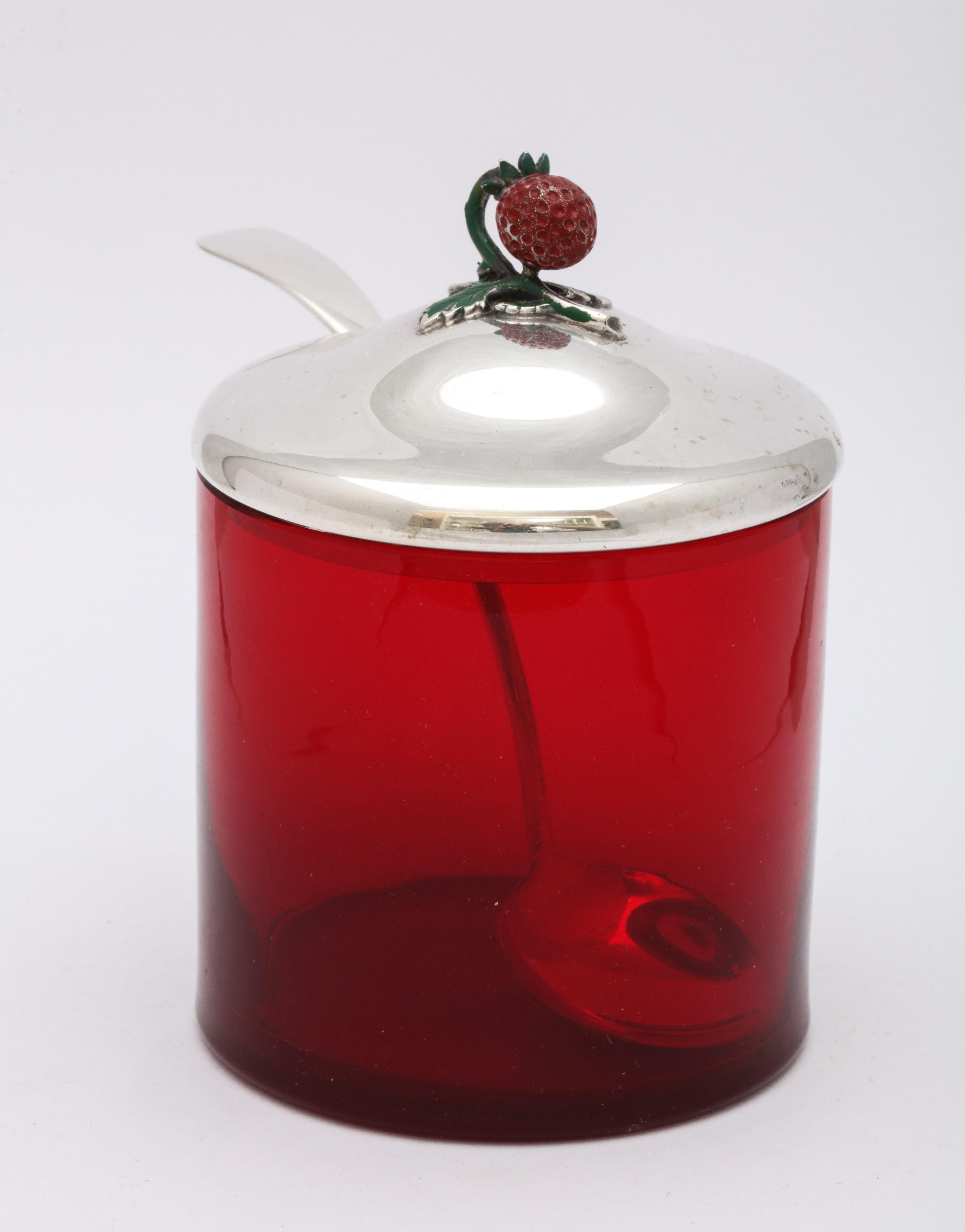 Art Deco, sterling silver-mounted, red glass condiments jar, having an enameled strawberry as a finial, and having its original spoon, R. Blackinton and Co., North Attleboro, Mass., circa 1930s. Measures 4 inches high (to top of finial) x 3 inches