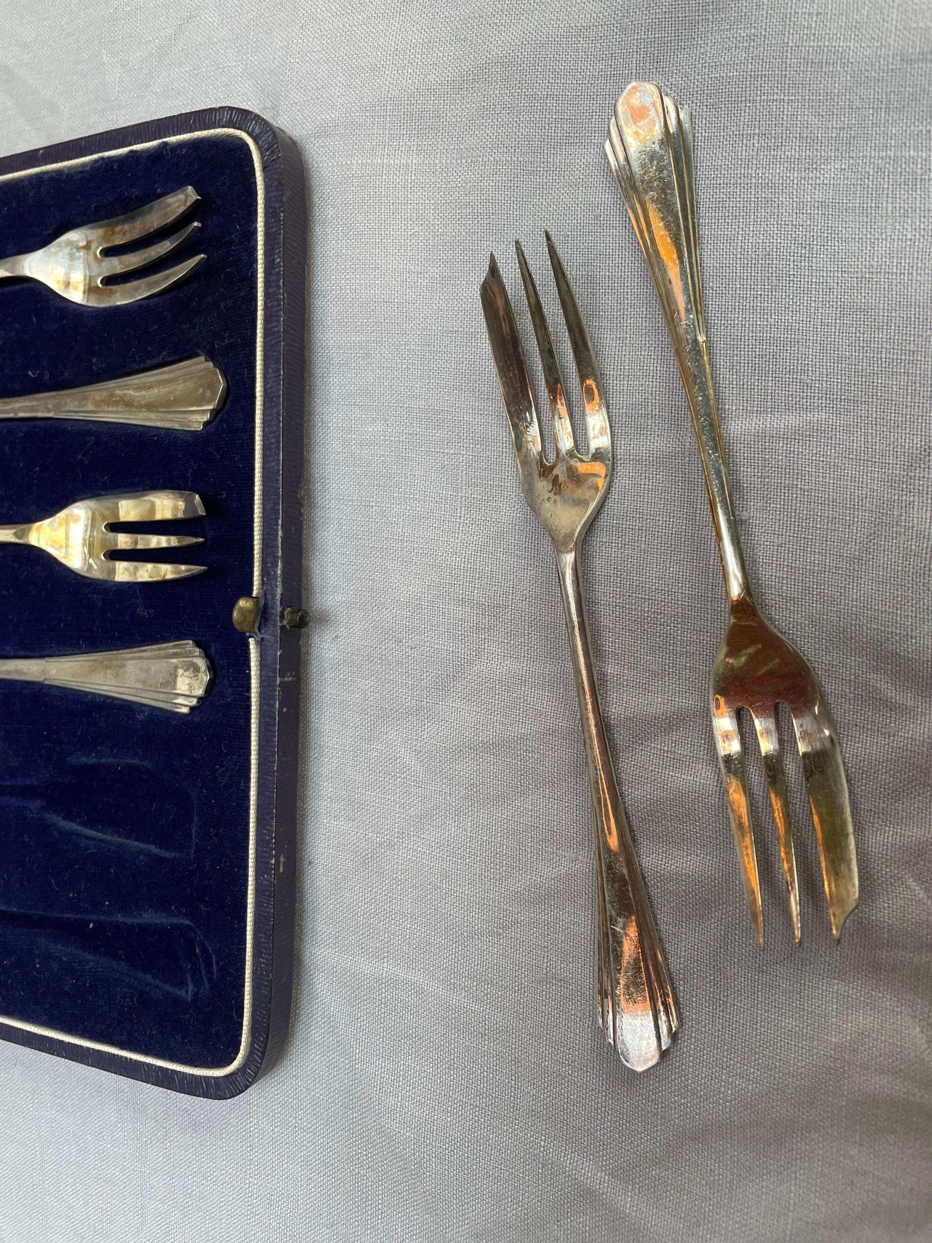 A refined boxed set of six sterling silver oyster forks with matching serving fork, crafted by James Deakin & Sons, one of Sheffield’s esteemed silversmiths, and fully hallmarked for Sheffield, 1941.

Each fork is elegantly styled in a streamlined