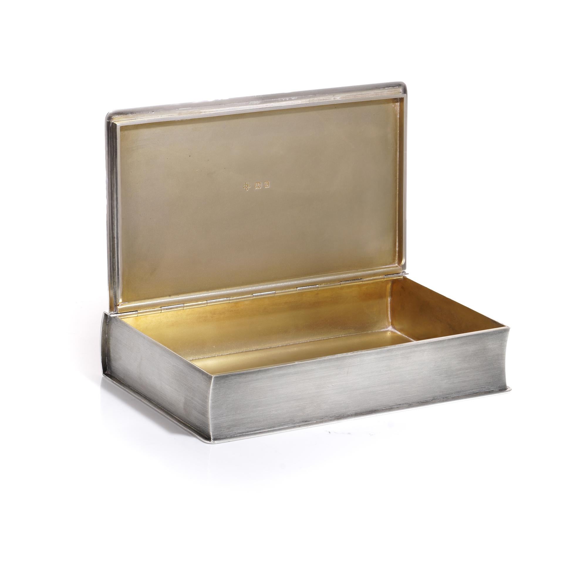 Art Deco sterling silver 925 sandwich/cigarette box featuring a silver gilt interior. The box is crafted in a book-style shape with engine-turned decoration.
Maker: William Base & Sons
Made in the United Kingdom, Birmingham, 1929 
Fully hallmarked