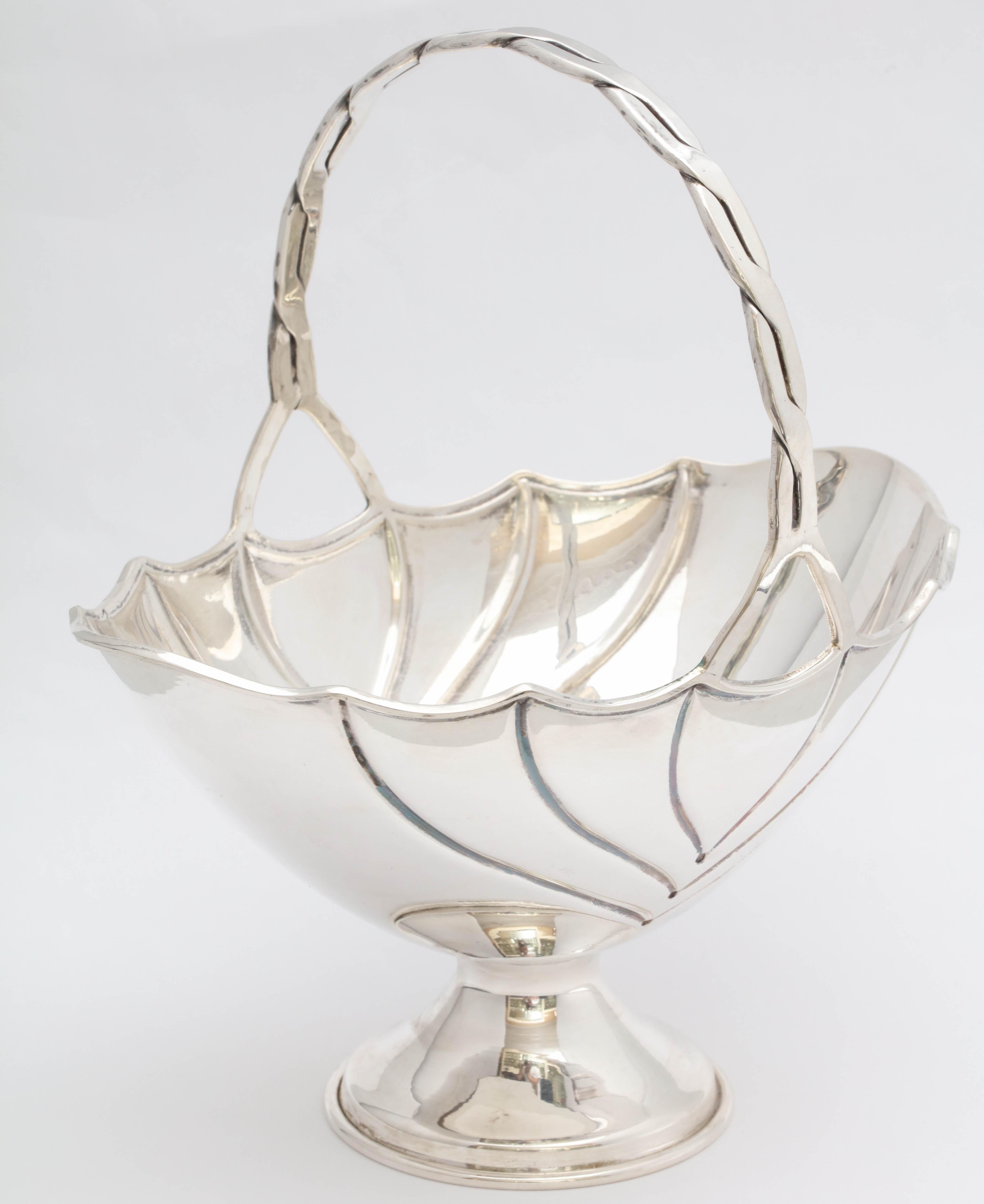 Art Deco, sterling silver table basket on pedestal base, American, circa 1930s. Measures: 8 1/4 inches high (to top of handle) x 7 inches wide (at widest point) x 5 inches deep (at deepest point); weighs 7.830 troy ounces. Lovely design. Dark spots