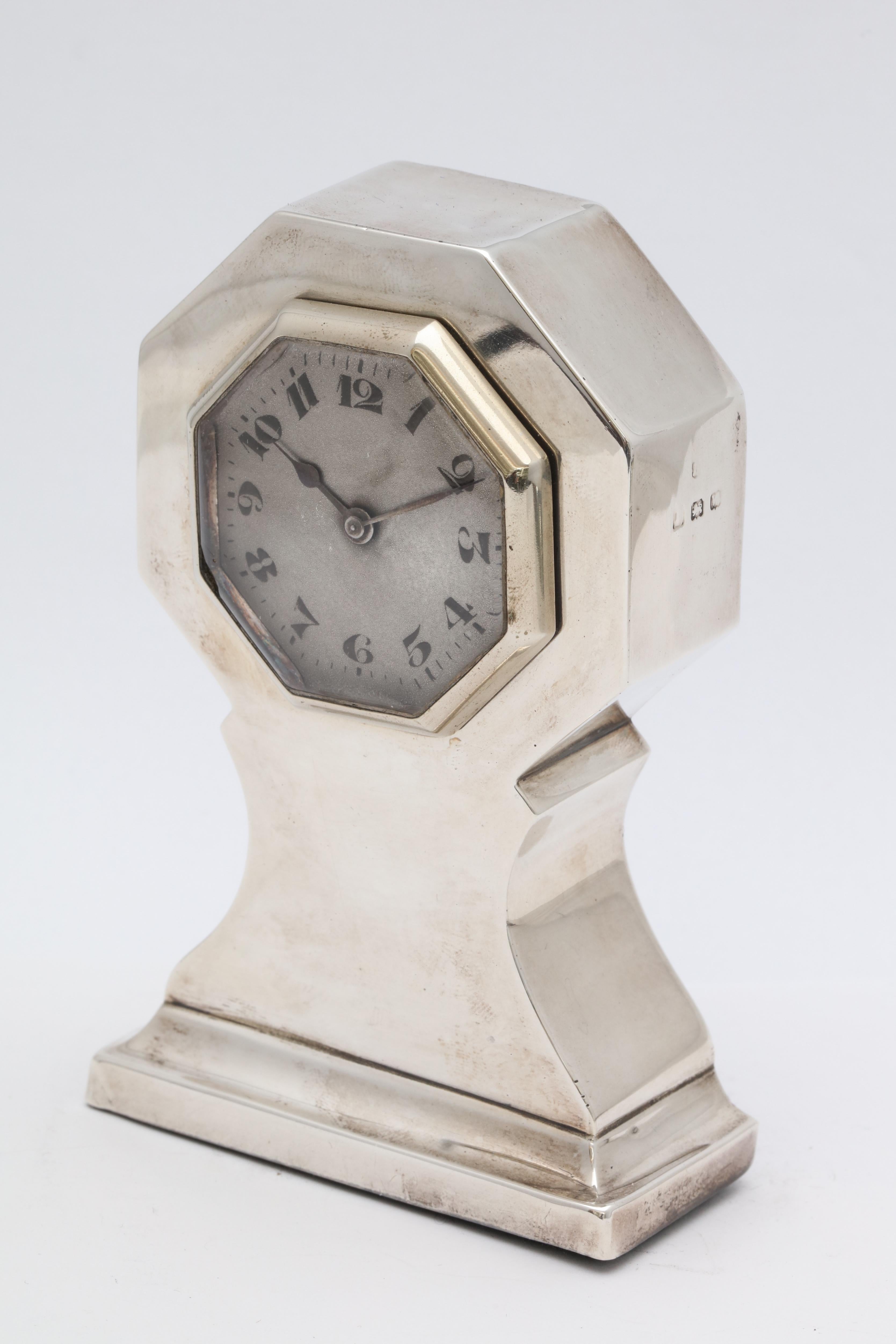 Art Deco, sterling silver, table clock, Birmingham, England, 1921, maker's mark rubbed. Stands 4 1/4 inches high x 2 3/4 inches wide (at widest point) x 1 1/4 inches deep. Wood back. Some very minor dints in the sterling silver, some minor scratches