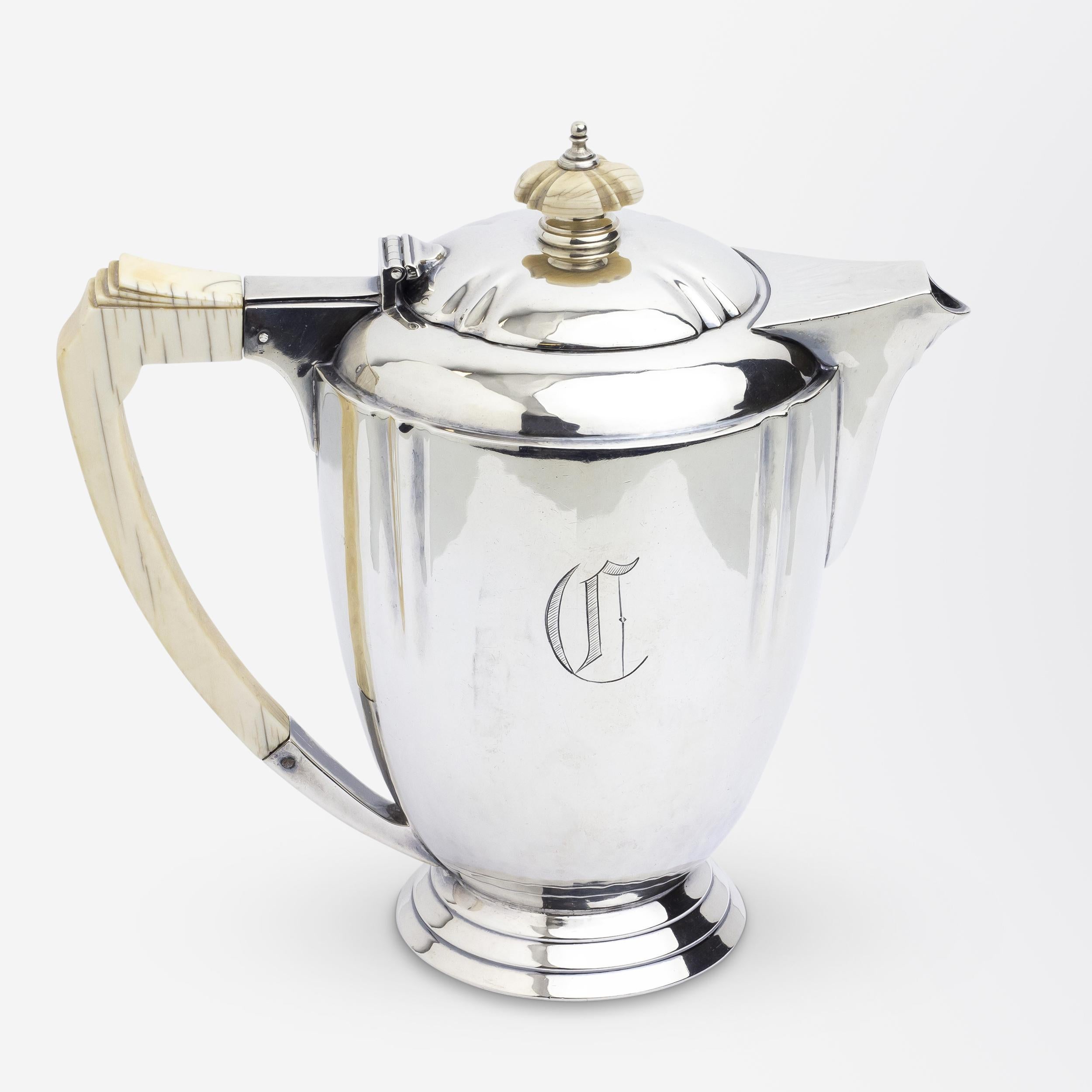 This four piece teaset has been crafted from sterling silver in England during the Art Deco period. The set comprises a coffee pot, a teapot, sugar and creamer which have been monogrammed with a 'C' to the centre front. The set is hallmarked for
