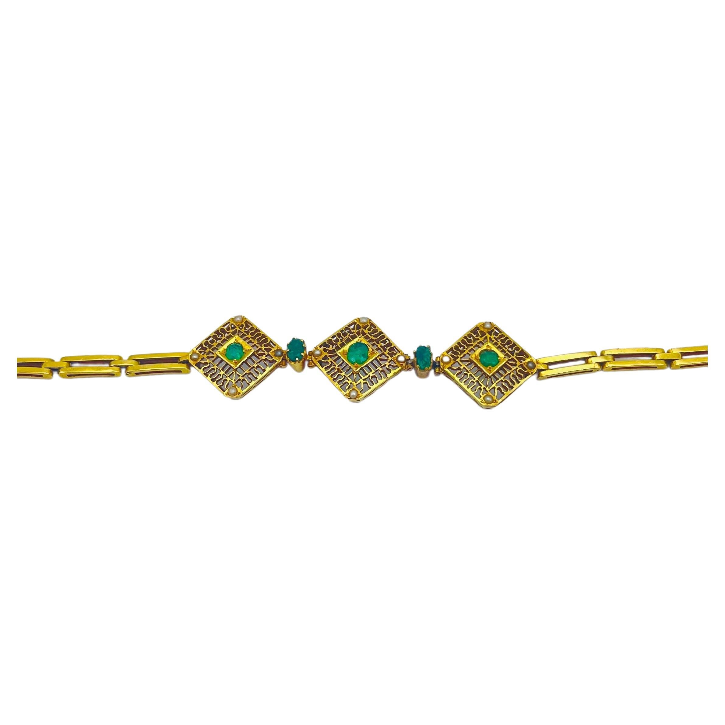
Tauchen Sie ein in die traumhafte Schönheit dieses sorgfältig gefertigten Armbands, ein Meisterwerk aus 14-karätigem Gelbgold im Stil des Art déco. Dieses atemberaubende Schmuckstück besticht durch seine Smaragde und Perlen und zeigt ein