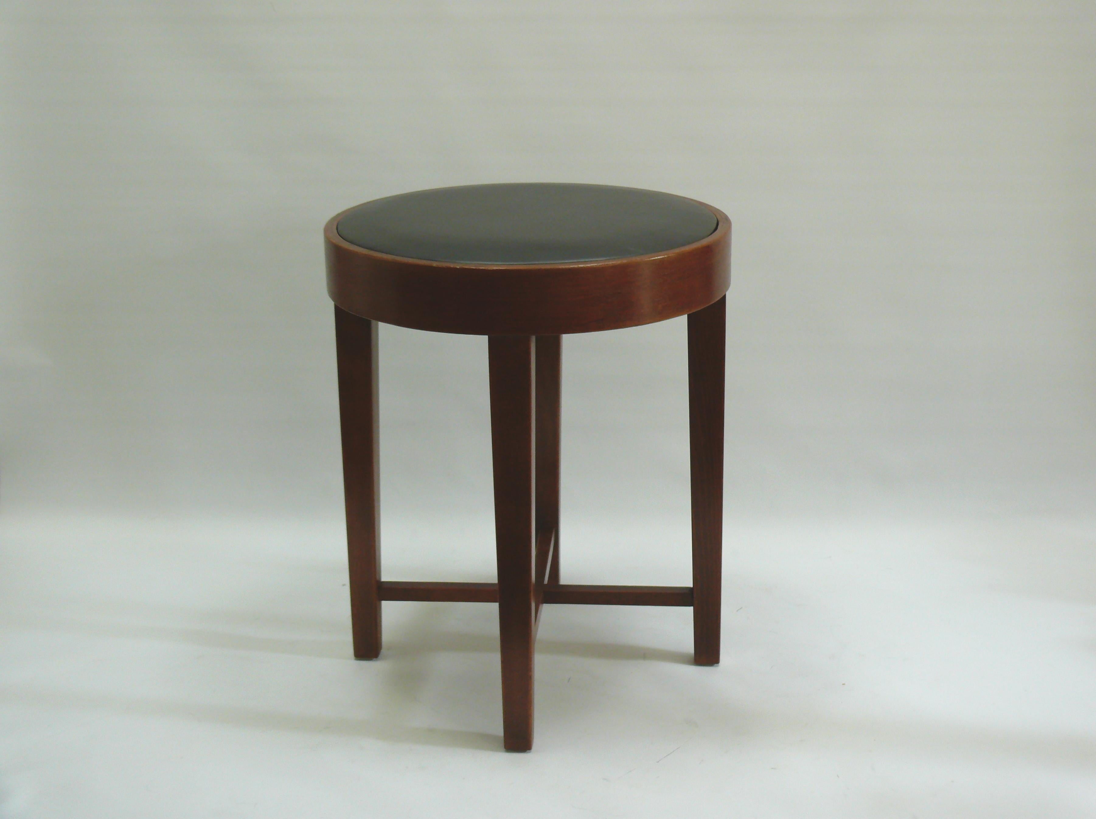Art Deco stool, upholstered with genuine leather, early to mid-20th century, in beautiful, restored condition. The stool is made of solid beechwood with a bent plywood seat ring and features a cross-shaped stabilizer underneath the seat for
