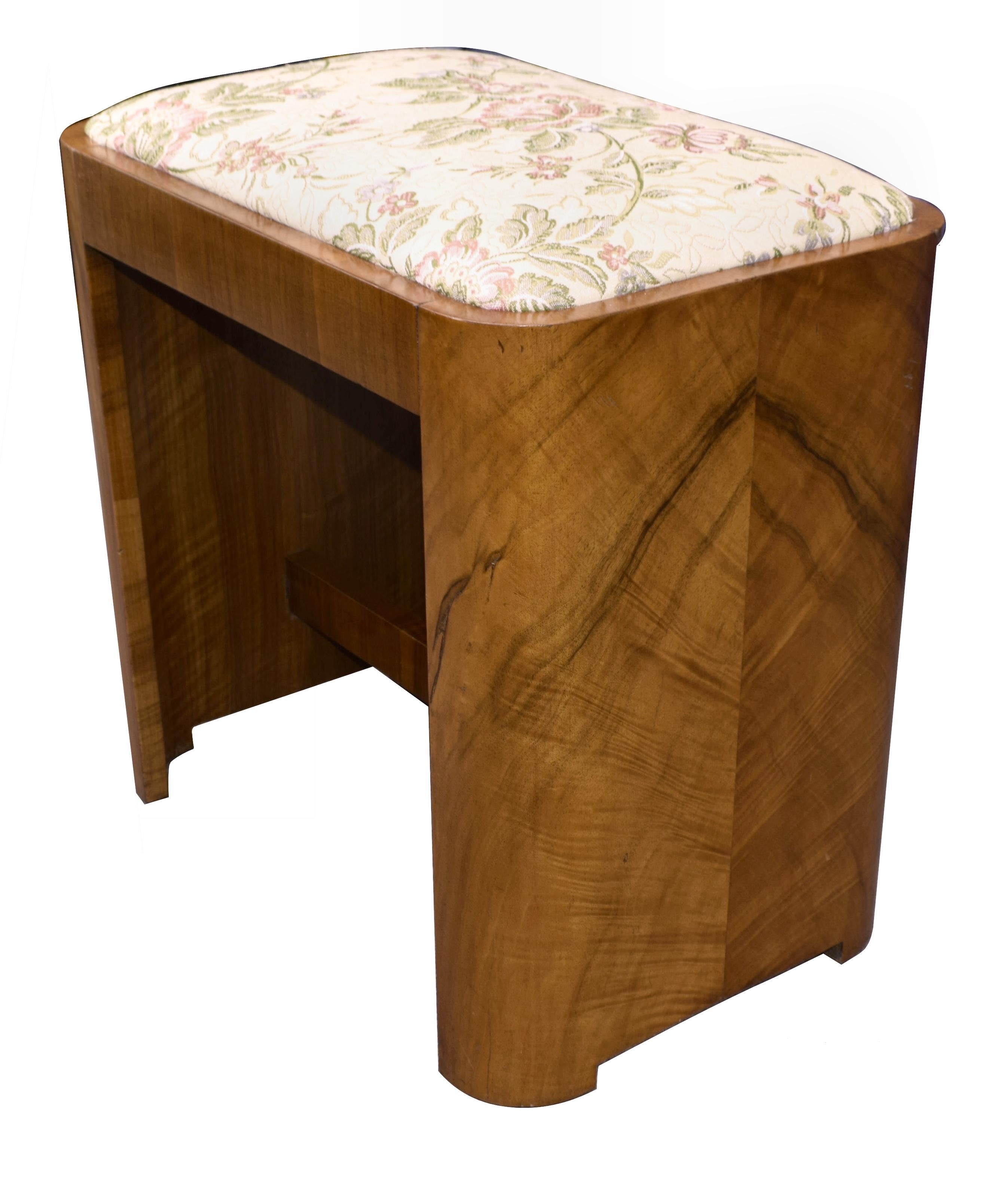 Very attractive, 1930s Art Deco figured walnut veneered stool. Although originally purposed as a bedroom stool there is nothing to stop you using this as a regular footstool. The two curved supports are the real hero of this piece, so simple and so
