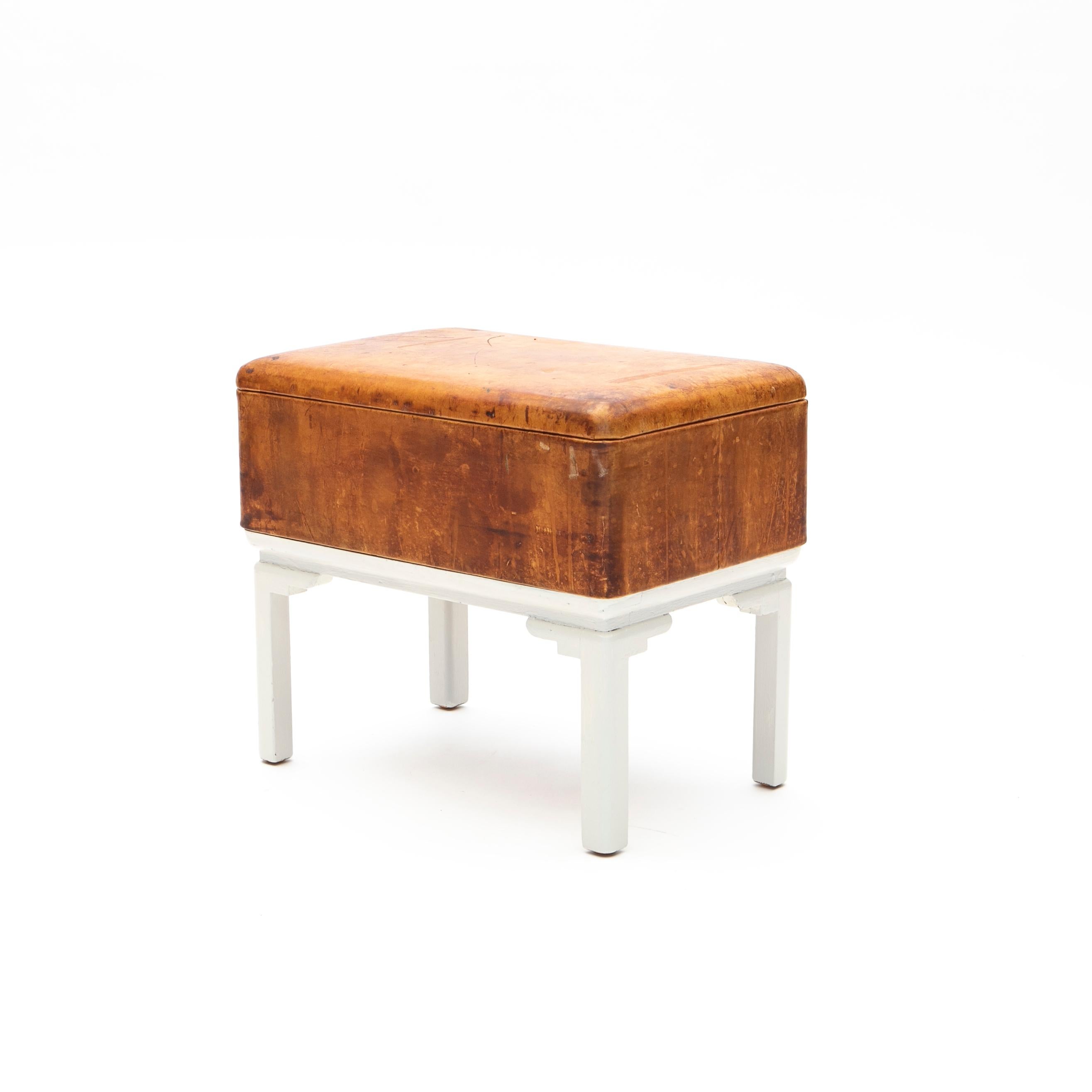 Danish art deco storage stool. 
Base in white painted wood. Seat with storage compartment.
Upholstered in natural leather.

Original leather with a beautiful age-related patina.
Denmark 1920-1930.
